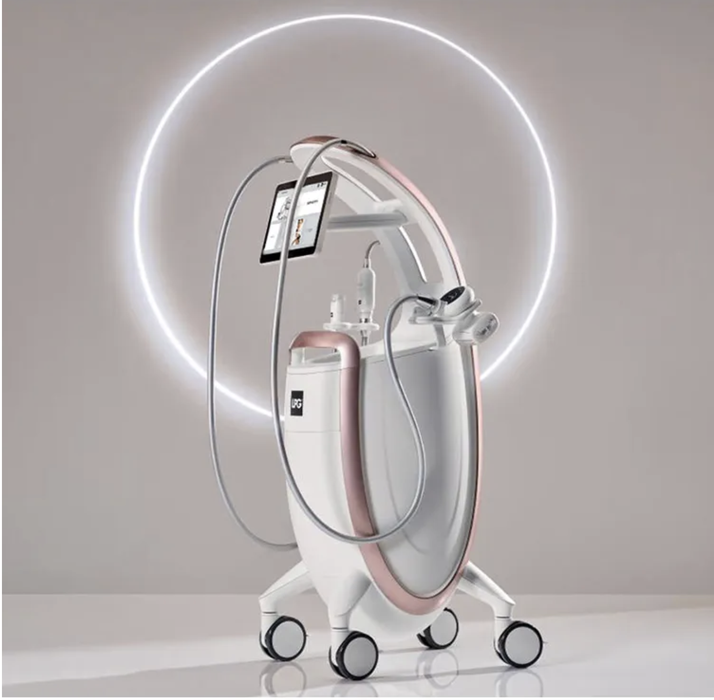 A futuristic medical device on a wheeled stand with a circular ring and various attached tools and screens, illuminated by a neon light.