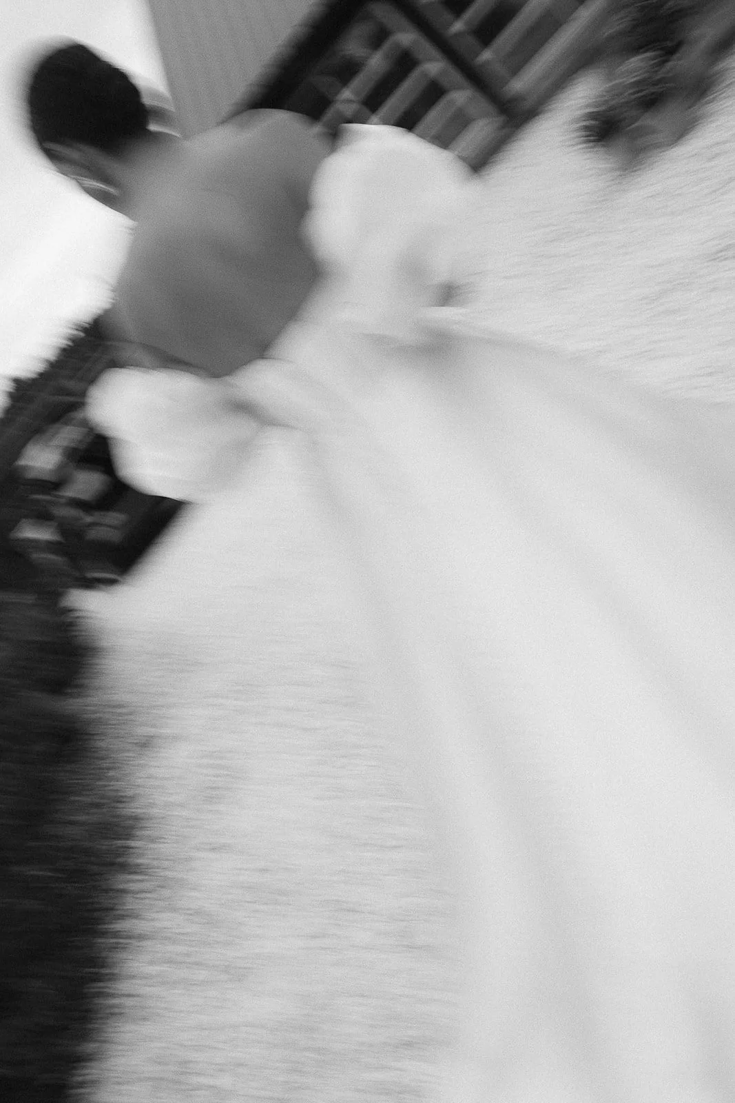 Blurred black and white photo of a bride running across the field at Peaches and Cream.