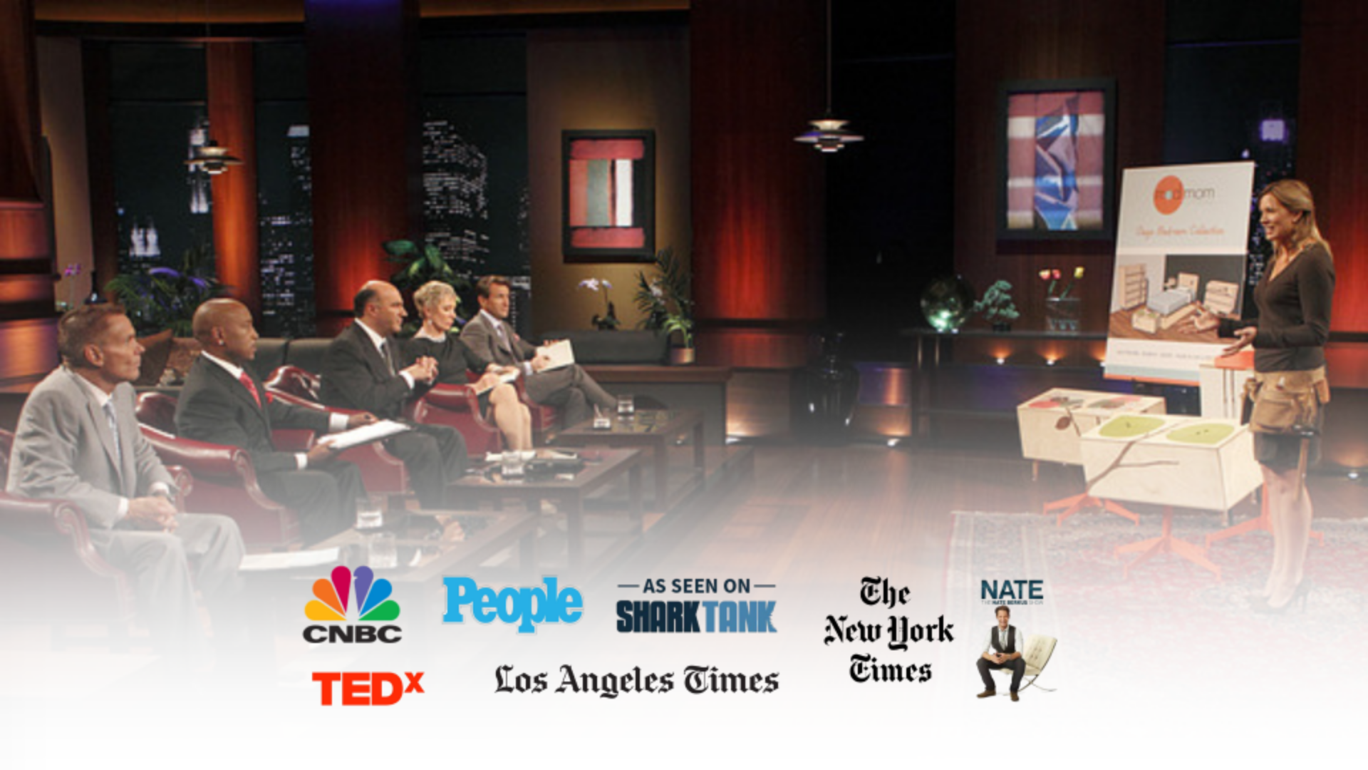 A panel of five people seated in red chairs on a television set, with a woman standing to the right giving a presentation. The background features cityscape images and abstract art. There are various logos at the bottom, including CNBC, People, Shark