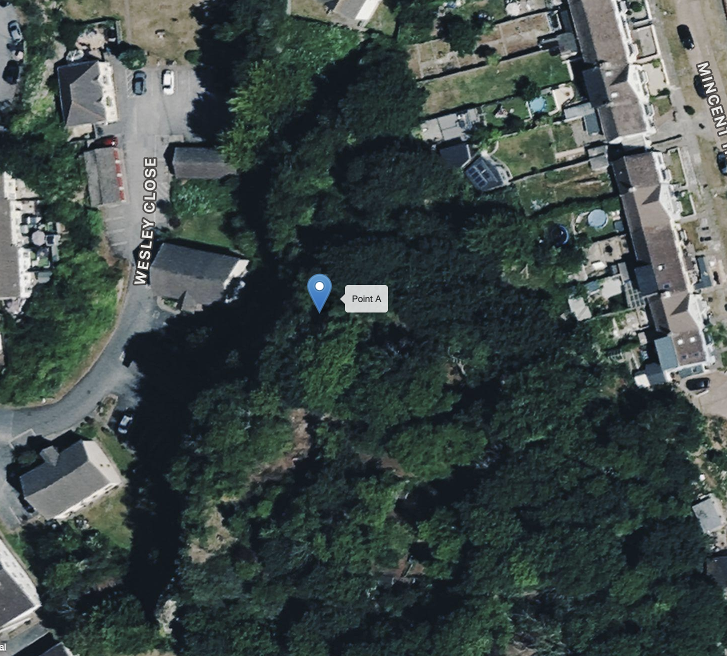 Aerial view of a neighborhood with trees, houses, and a small parking lot on Wesley Close, with a 'Point A' marker indicating a specific location in a wooded area.