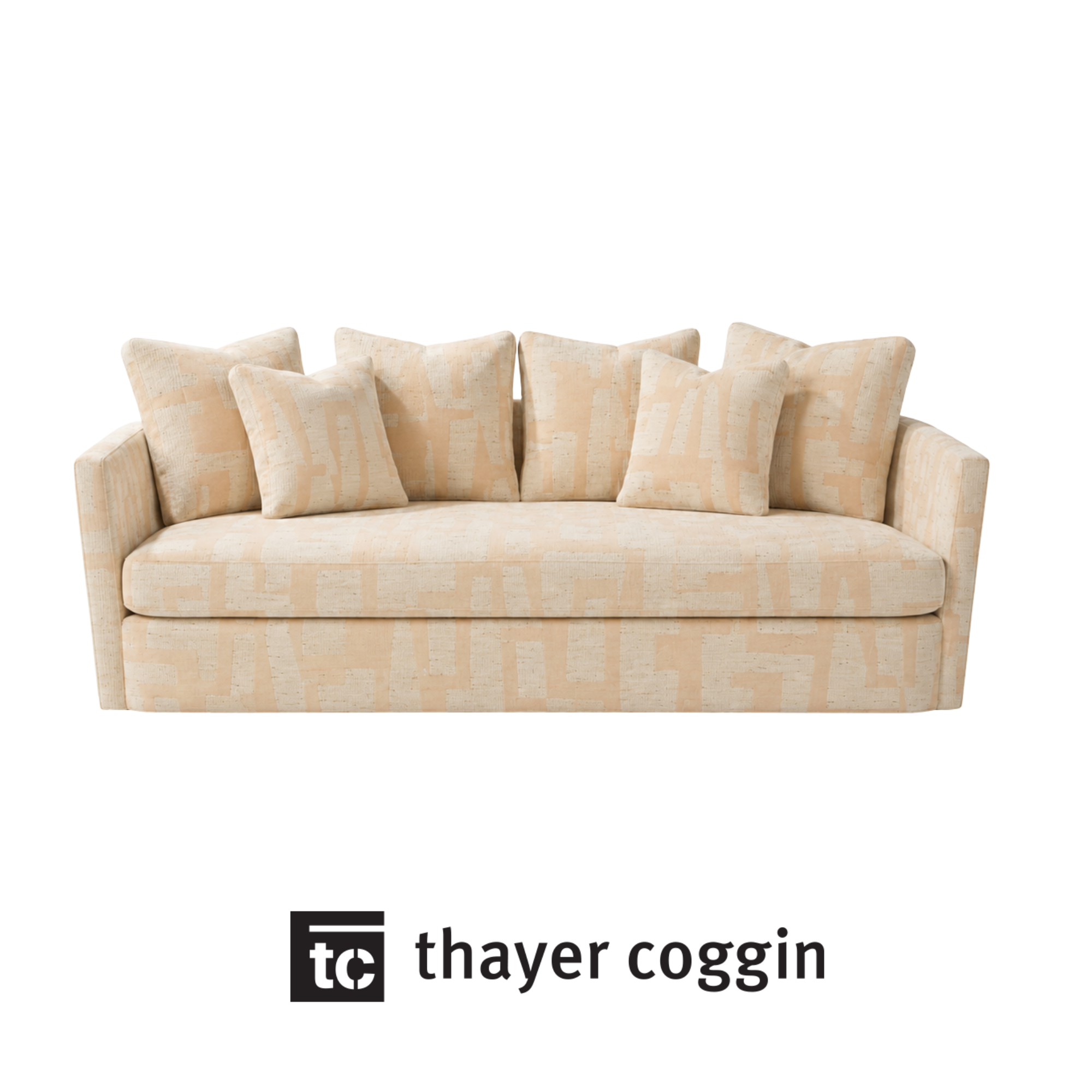 A beige sofa with several matching cushions bespoke made by Thayer Coggin using Kravet fabric.
