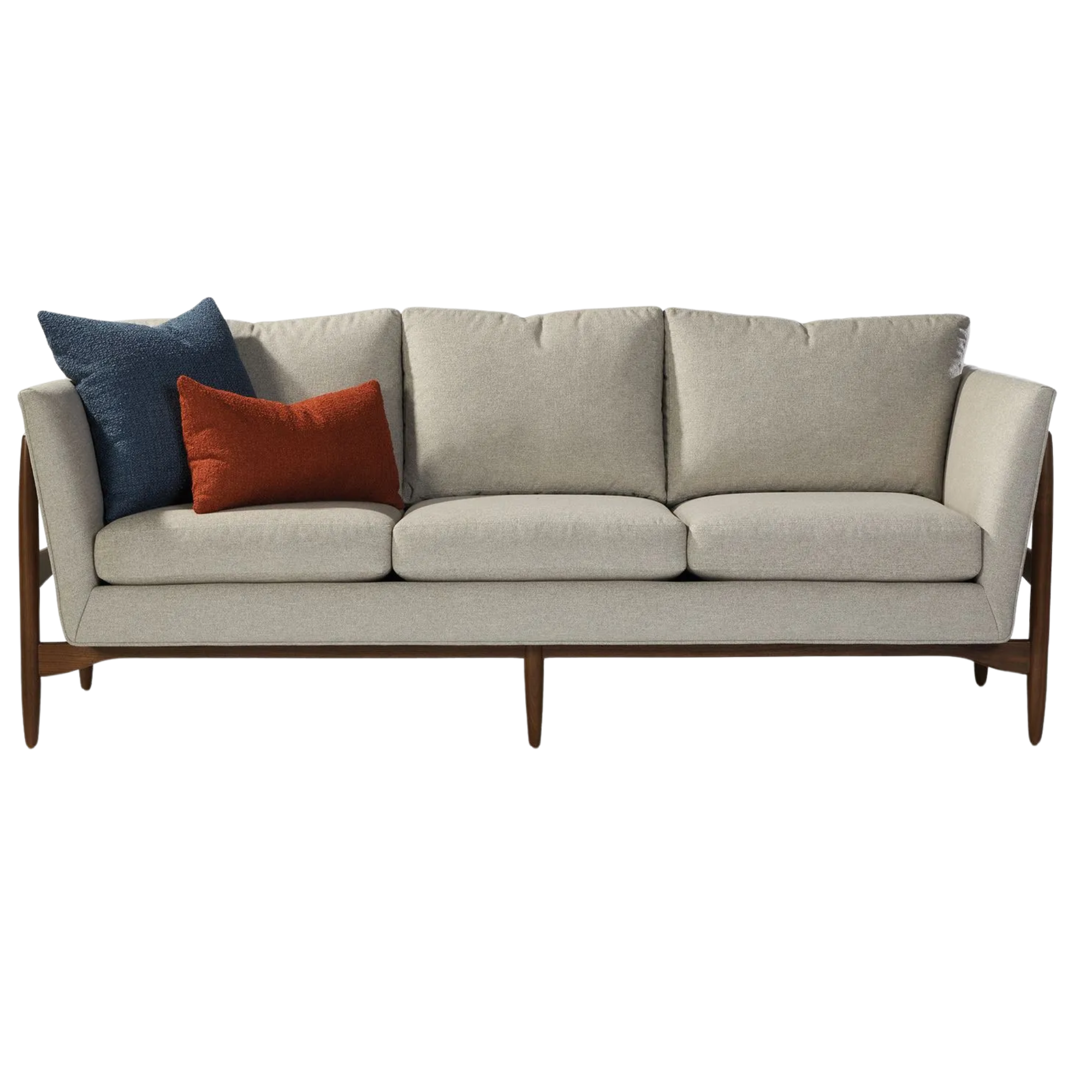 A beige mid-century modern sofa with dark wood legs, decorated with a navy blue throw pillow and an orange throw pillow custom made by Thayer Coggin.