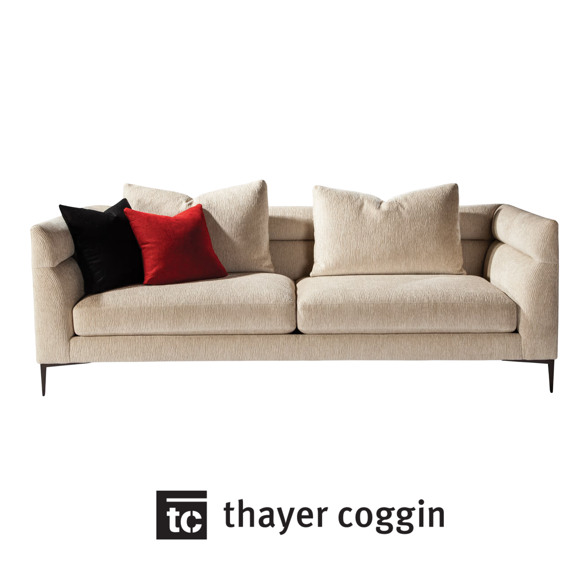 A beige upholstered Thayer Coggin sofa with custom black and red cushions.
