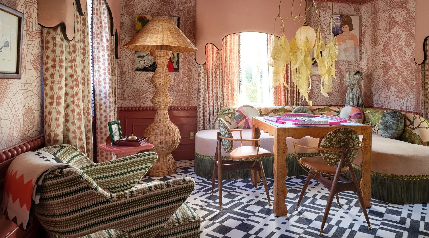 Eclectic living room with patterned wallpaper, striped curtains, wicker lamp, patterned furniture, and a black and white geometric tile floor.