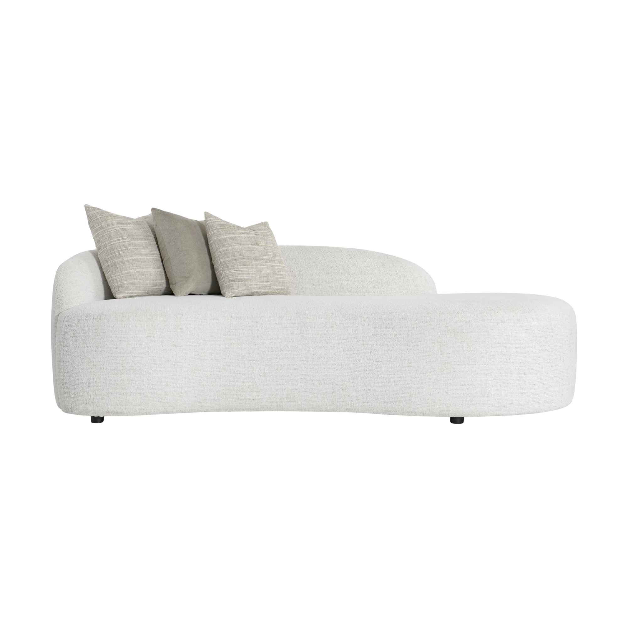 A modern, minimalist living room with a white curved sofa adorned with beige and light brown striped pillows provided by bernhardt furniture.