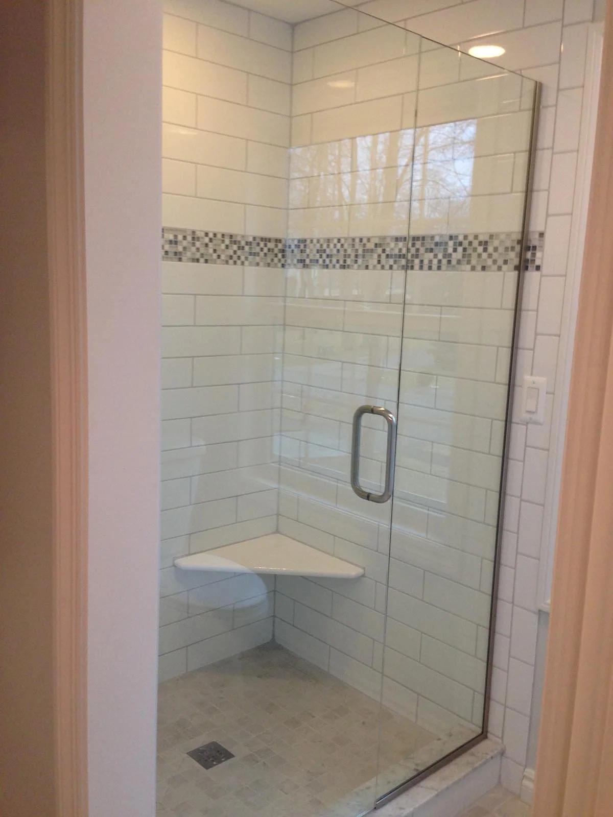Breza master bath included: new ceramic subway tile with black and grey accent glass, granite seat and corner shelves, frameless tempered glass shower door.