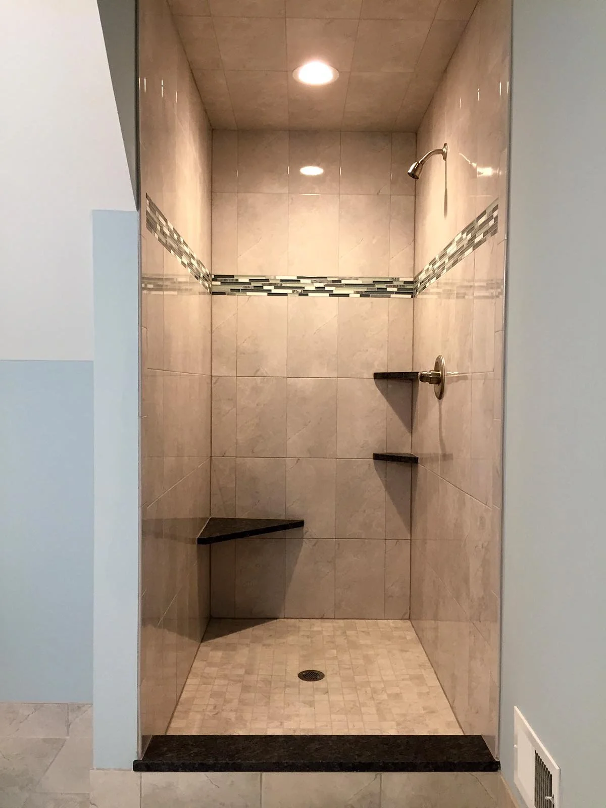 Old North River hall bath shower included: ceramic wall tile with horizontal glass accent, granite seat, corner shelves and sill.