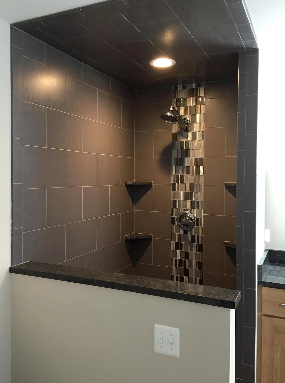Old North River master bath shower work included: new porcelain wall tile with vertical glass accent, black granite sills, shelves and vanity top.
