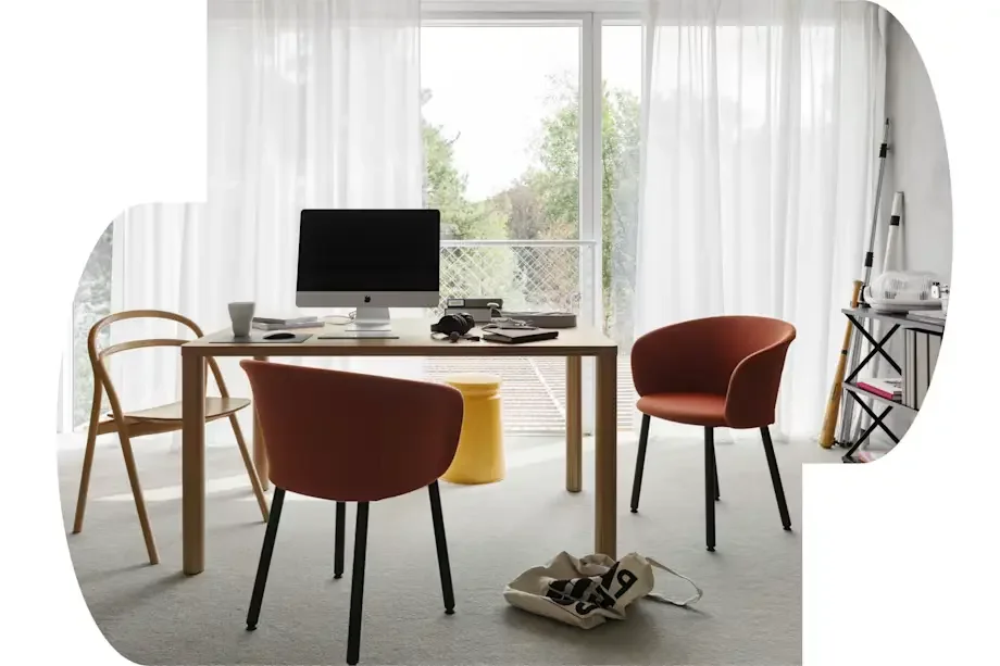 Home office with a desk, computer, chairs, and a large window with white curtains.
