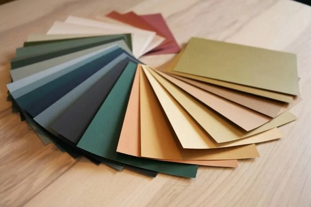 Échantillons de papier de différentes couleurs disposés en cercle sur une surface en bois.
