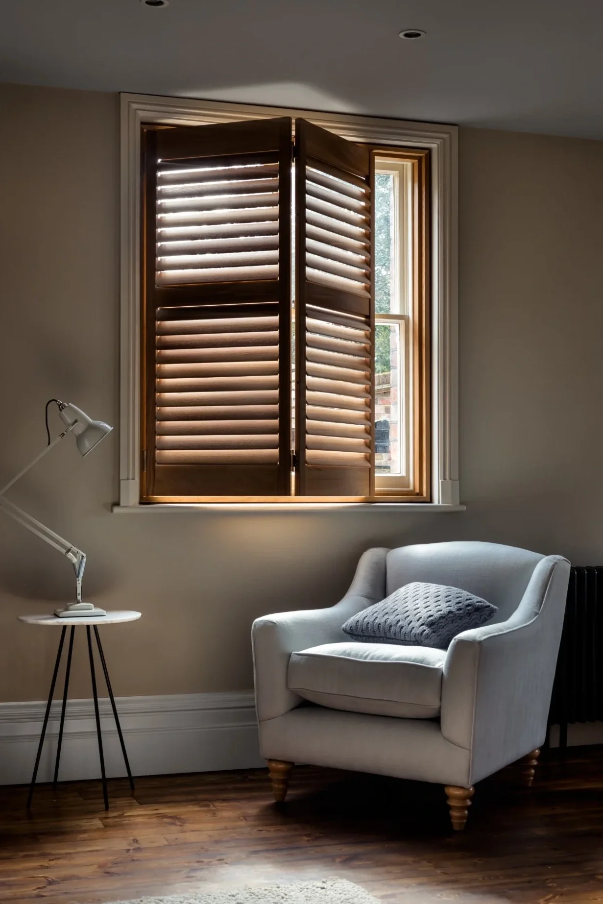 Patoma Ashwood full height plantation shutters with open adjustable louvres in a contemporary reading room, showcasing the natural wood grain, made-to-measure fit and precise light control.