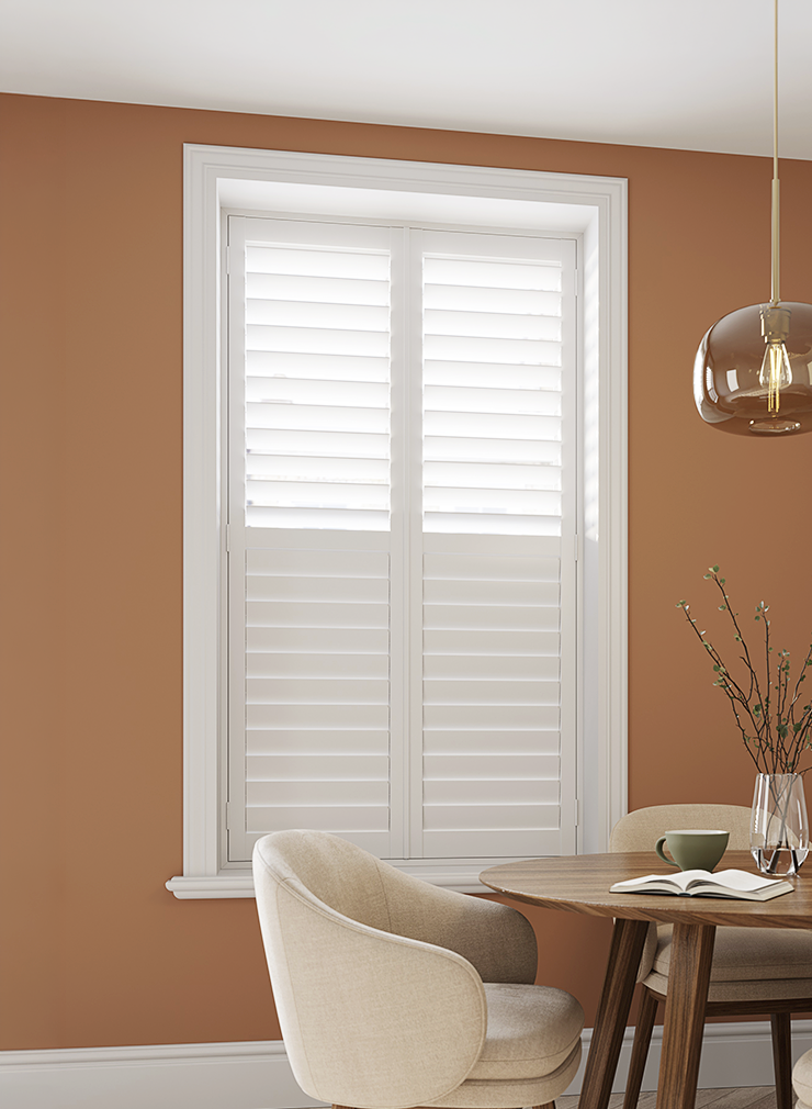 White full height window shutters with split tilt louvres and hidden tilt rods in a contemporary dining room.