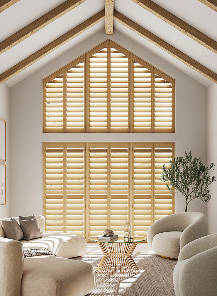 Bespoke shaped natural wood window shutters fitted to a gable end window in a contemporary living room.