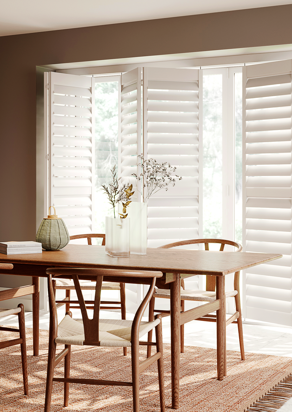 White tracked window shutters with wide louvres fitted across large dining room windows.