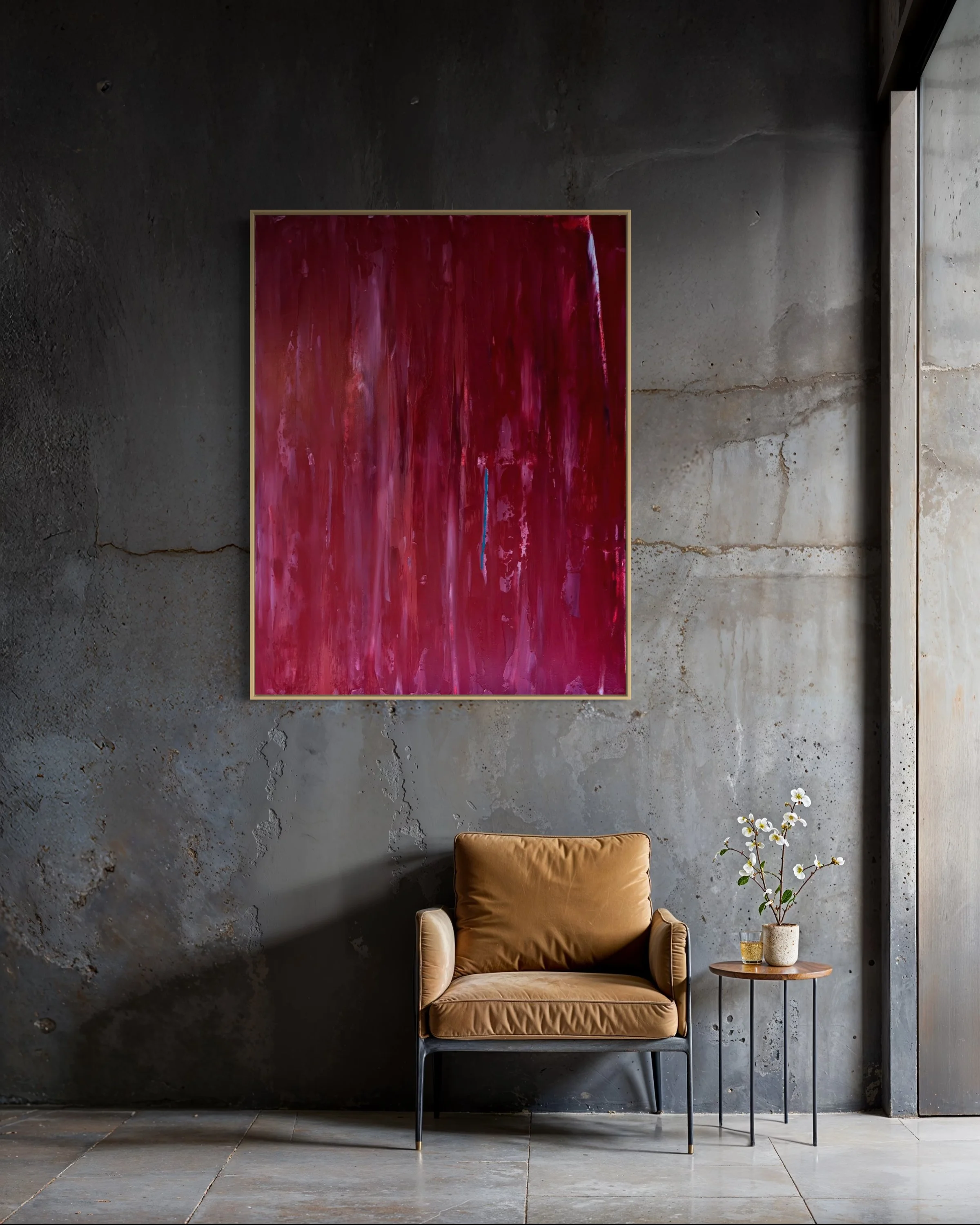 Interior space with a dark grey concrete wall, a yellowish-brown armchair, a small round wooden side table with potted white flowers, and a blue abstract painting, ALMOST by Paul Bell on the wall.