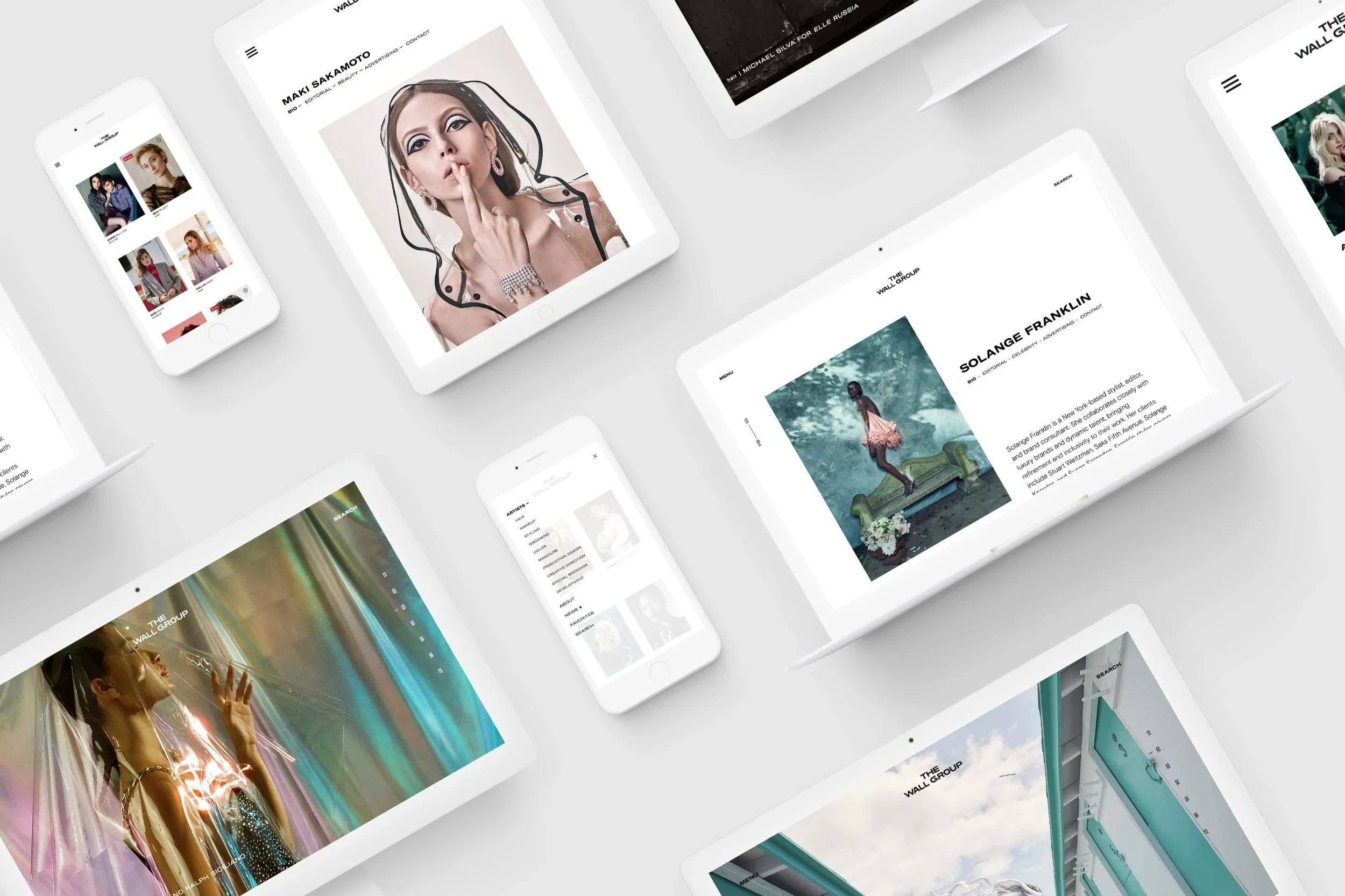 Multiple digital screens and smartphones displaying various websites and images, including portraits, fashion photography, and artistic visuals, all arranged on a light-colored surface.