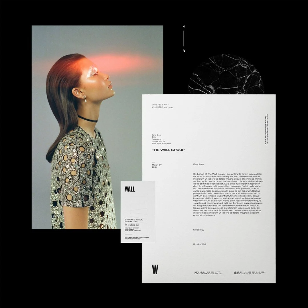 A woman with brown hair and sparkling eye makeup stands sideways with her eyes closed, wearing a patterned dress. Surrounding her are various documents and images, including a white letter, a smaller card, and a textured black circle on a black background.
