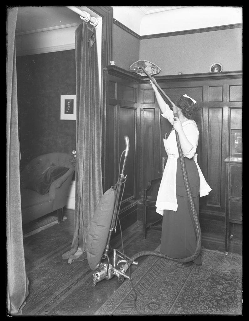 Unidentified woman vacuuming ca. 1910