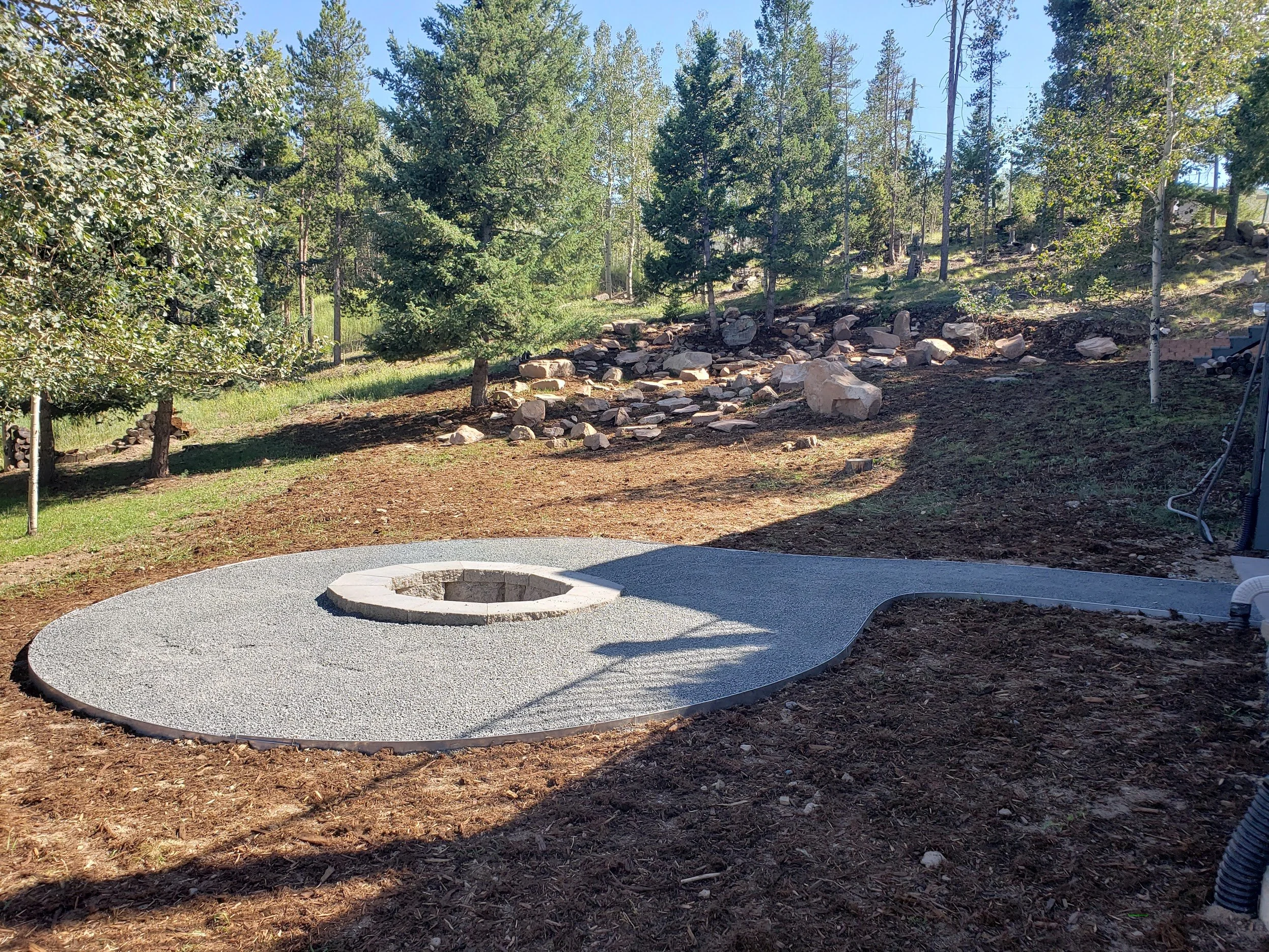Recessed wood burning fire pit with surround to fit chairs on hillside