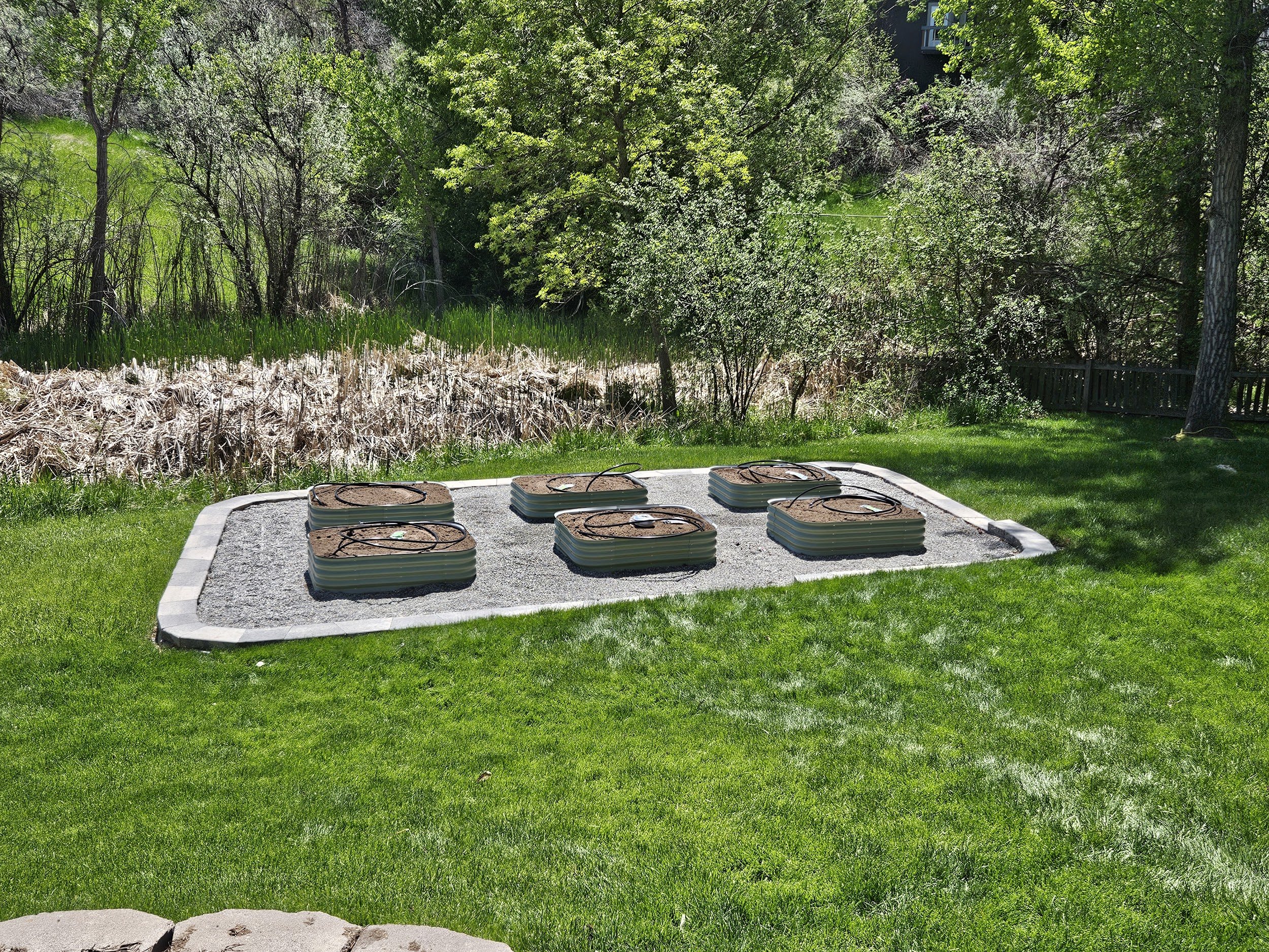 Large retaining wall block and cap planter that holds six small metal planters for gardening