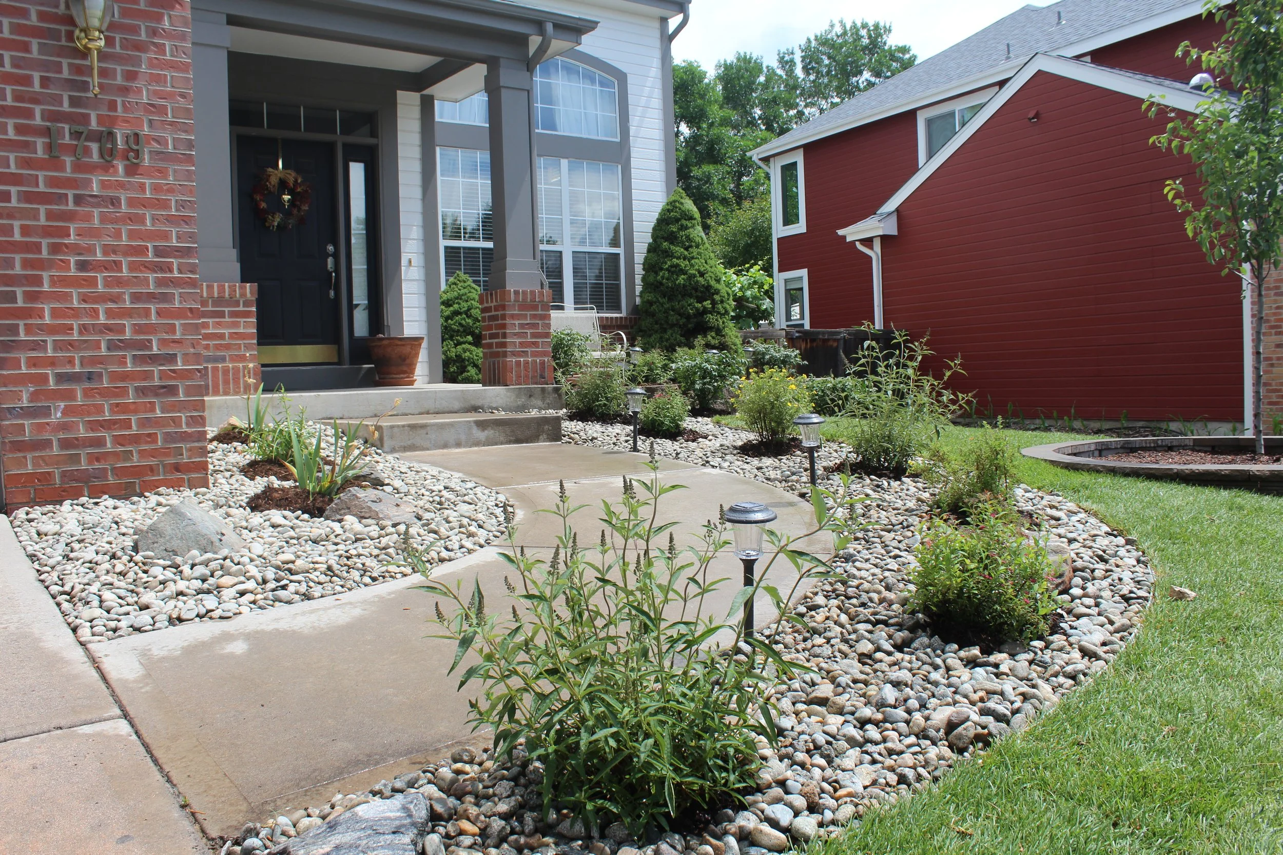 Entry way river rock with butterfly bush and other small shrubs