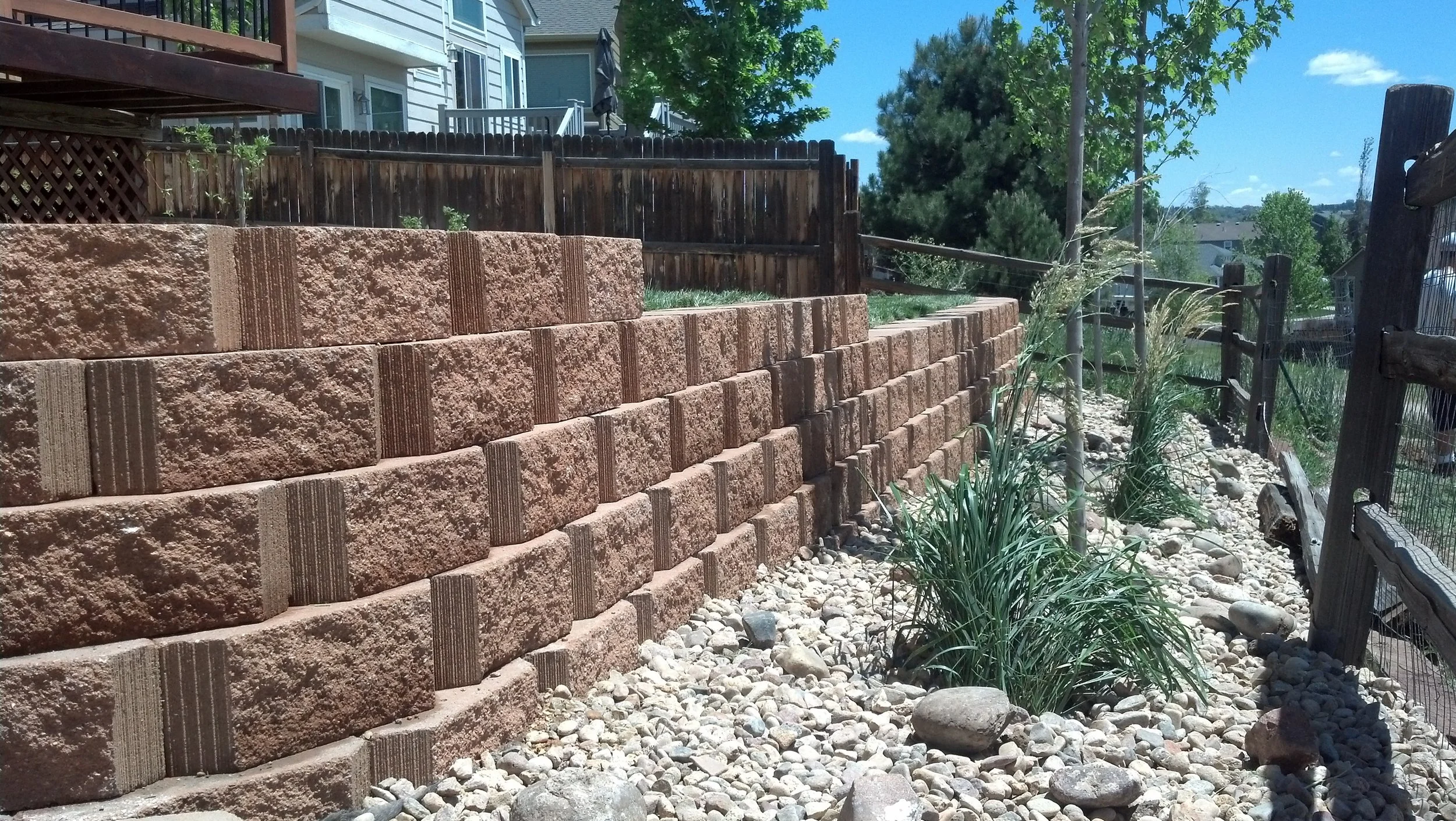 Parker back yard retaining wall to level yard planted with shrubs trees and sod on top