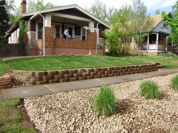 Boulder front yard retaining wall with sod 