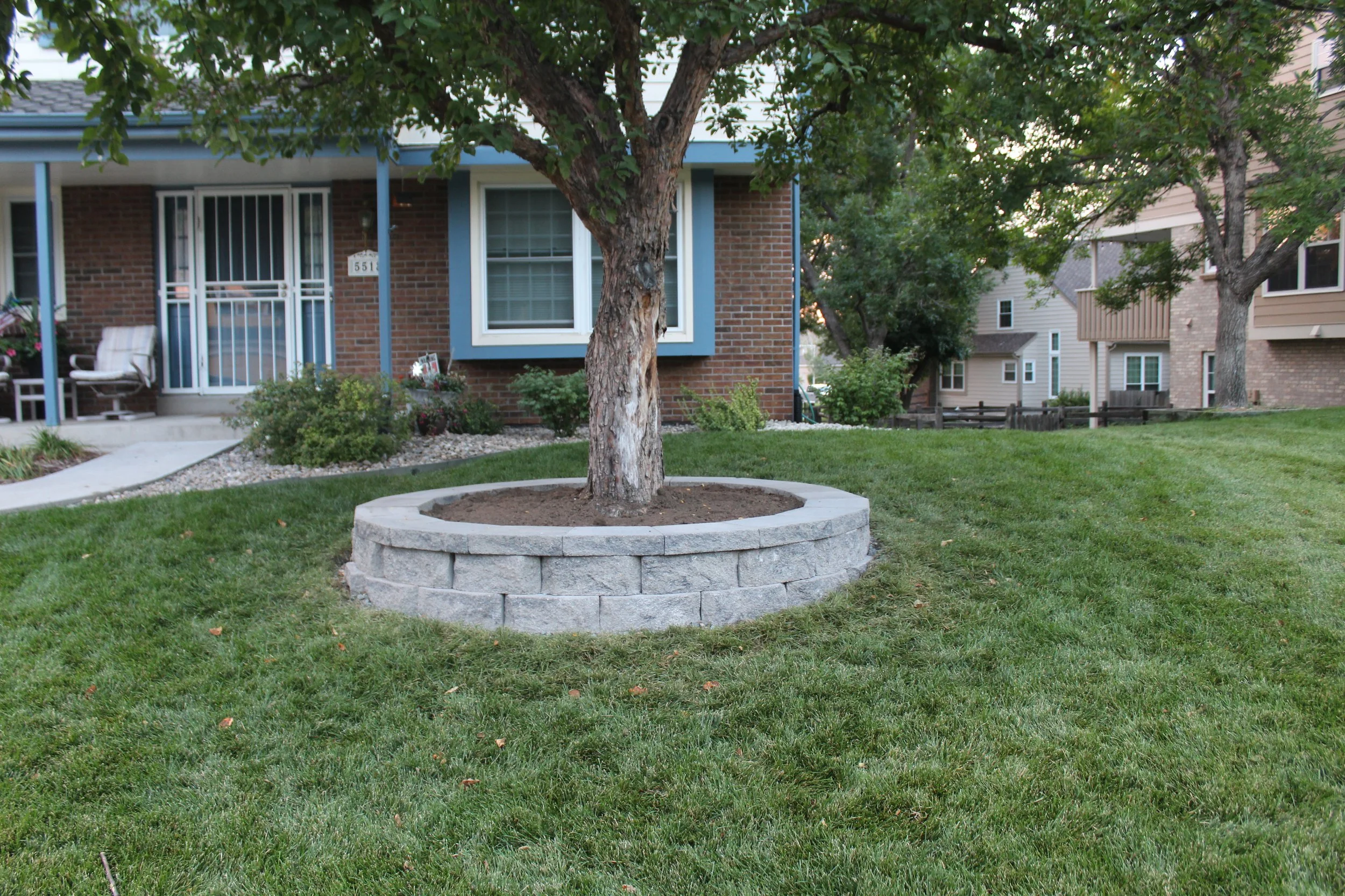 Retaining wall block and cap planter around tree in front yard