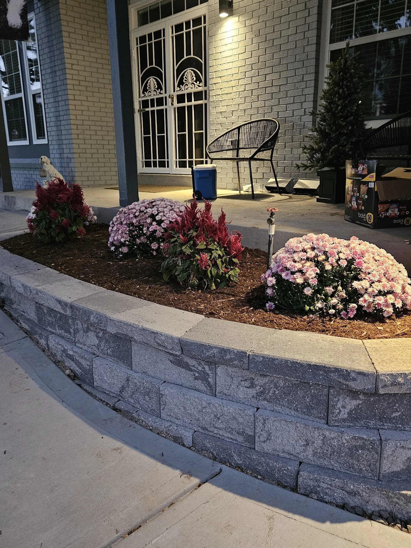 Retaining wall block and cap planter on front porch with flowers planted inside