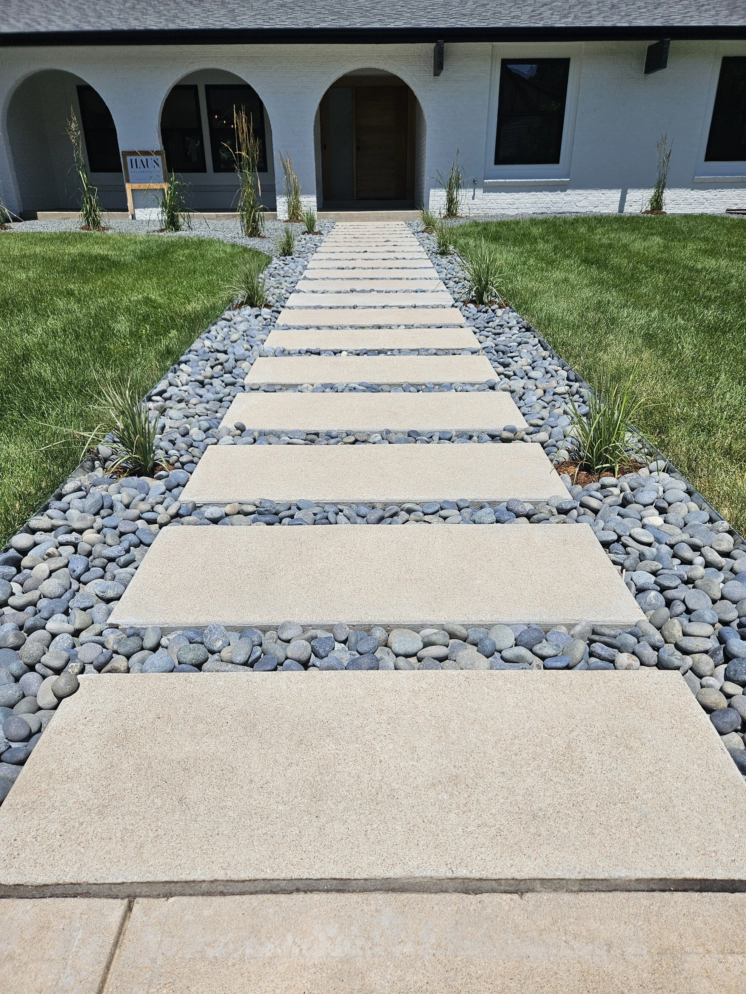 South Denver concrete walkway with Mexican Beach Pebbles and small shrubs