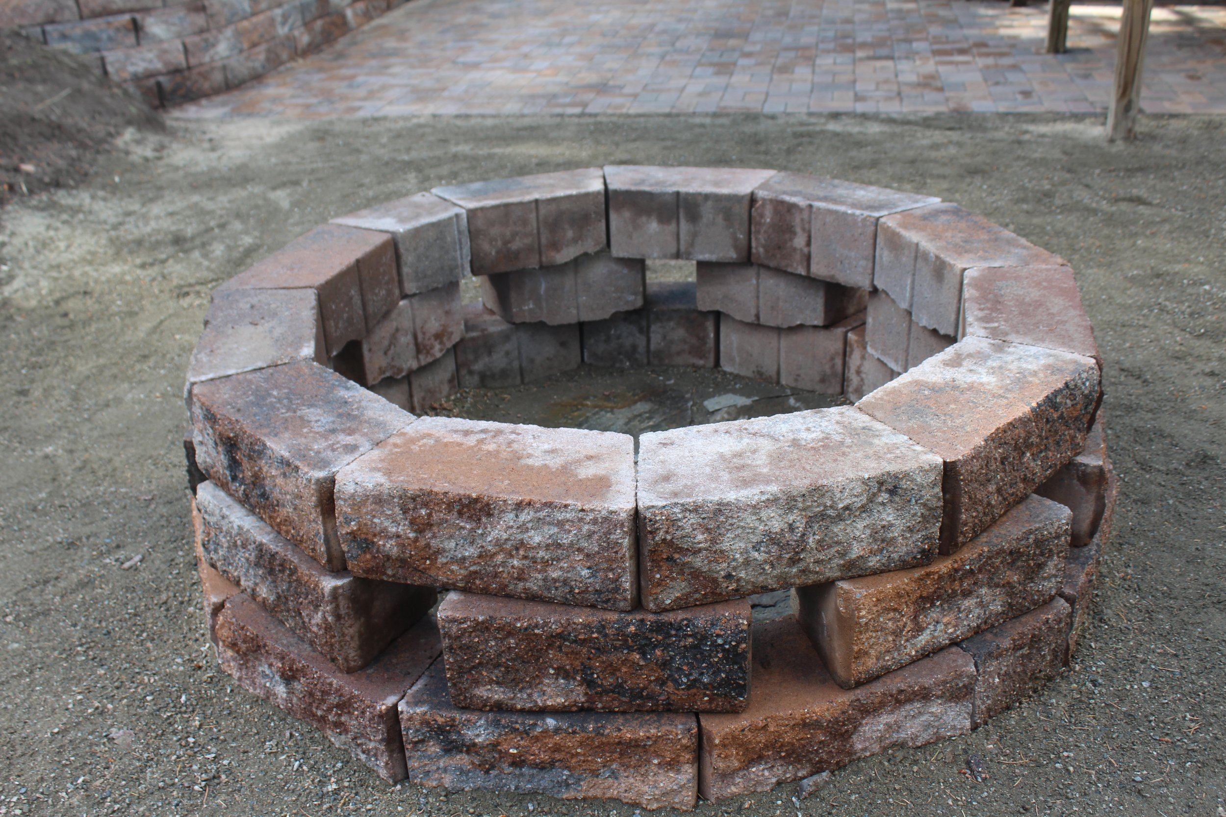 Wood burning fire pit with retaining wall block to match the paver patio and retaining walls