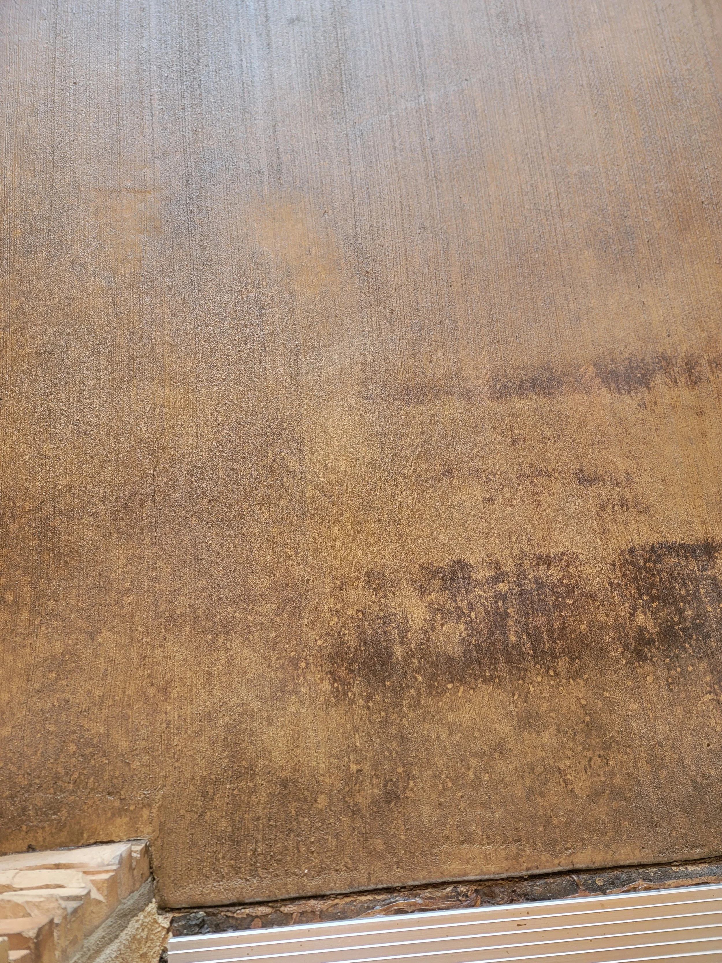 Close-up of a textured, weathered metal or wooden surface with visible layers and rust.