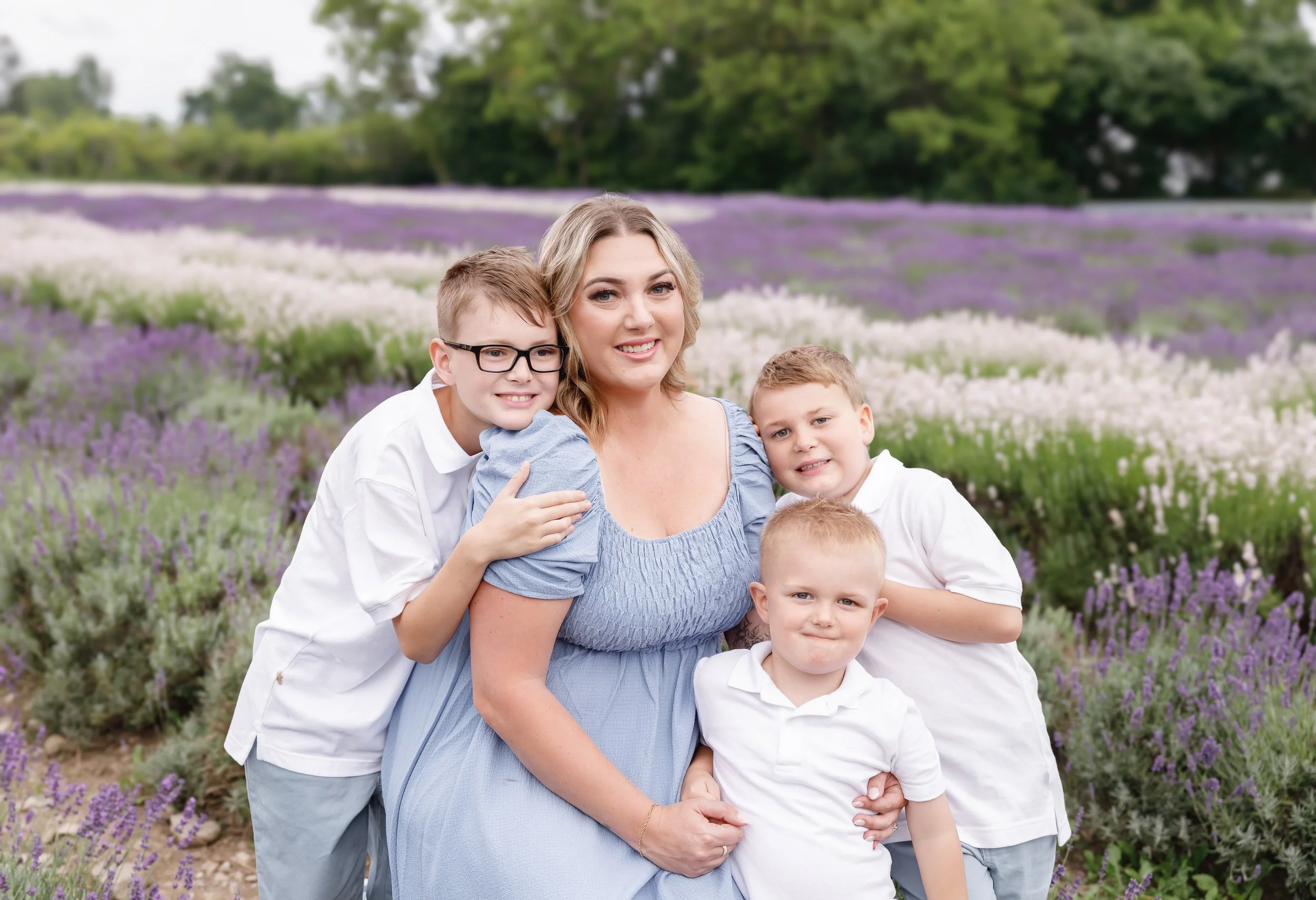 A woman and four children standing in a lavender field, smiling at the camera.
