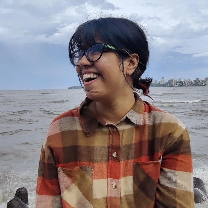 Indian woman dressed in a red, brown, and cream plaid shirt