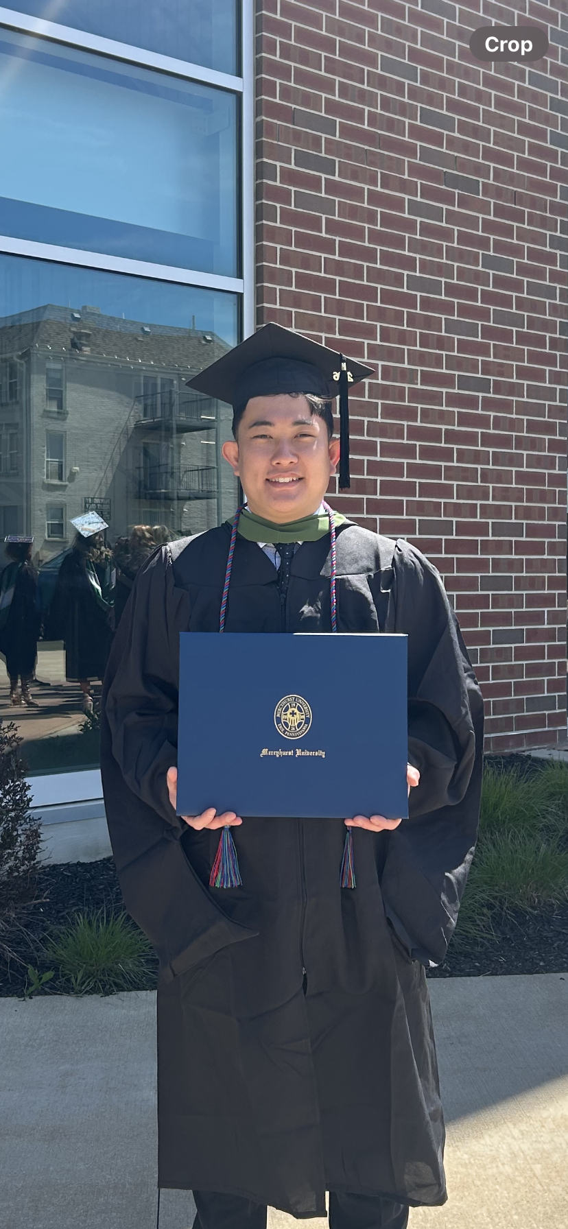 Student in cap and gown holding his diploma