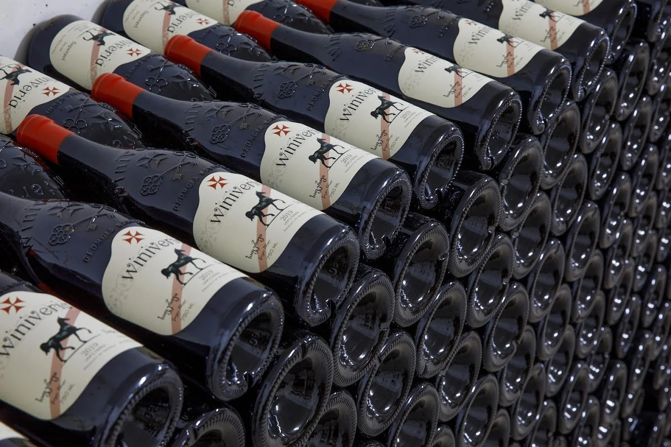 Multiple bottles of Winner wine stacked horizontally on top of each other.