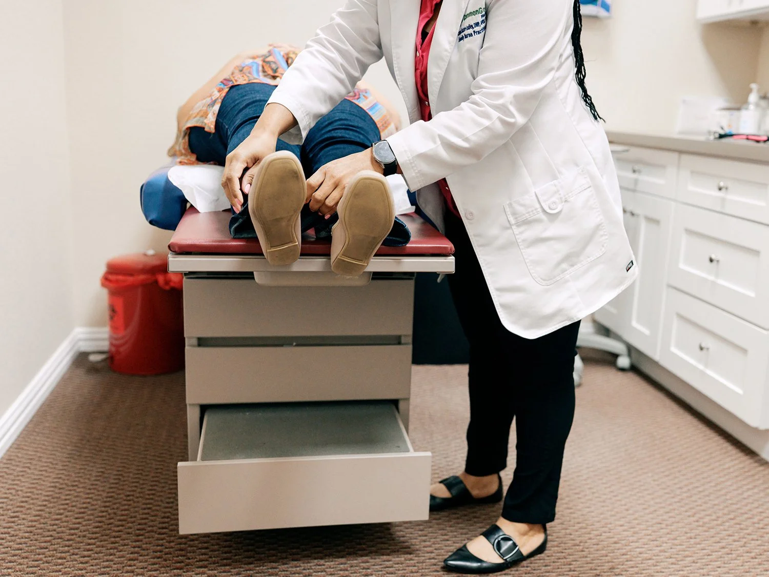 Doctor preparing a patient on an examination table in a medical office