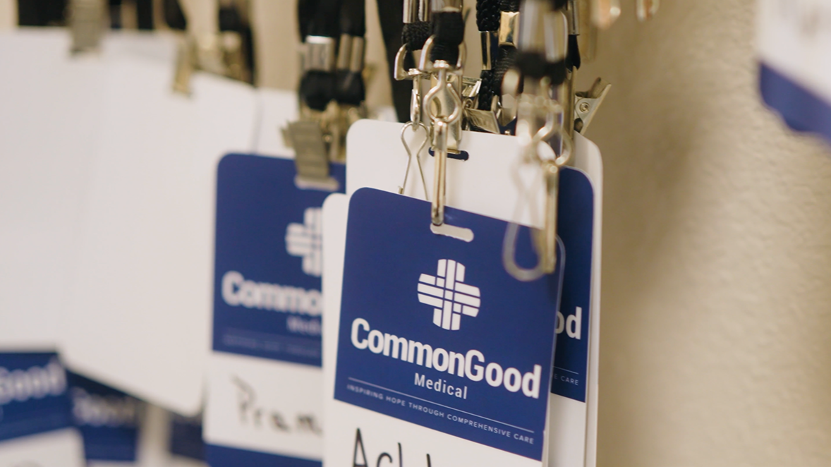 Close-up of blue CommonGood Medical ID badges hanging on hooks.
