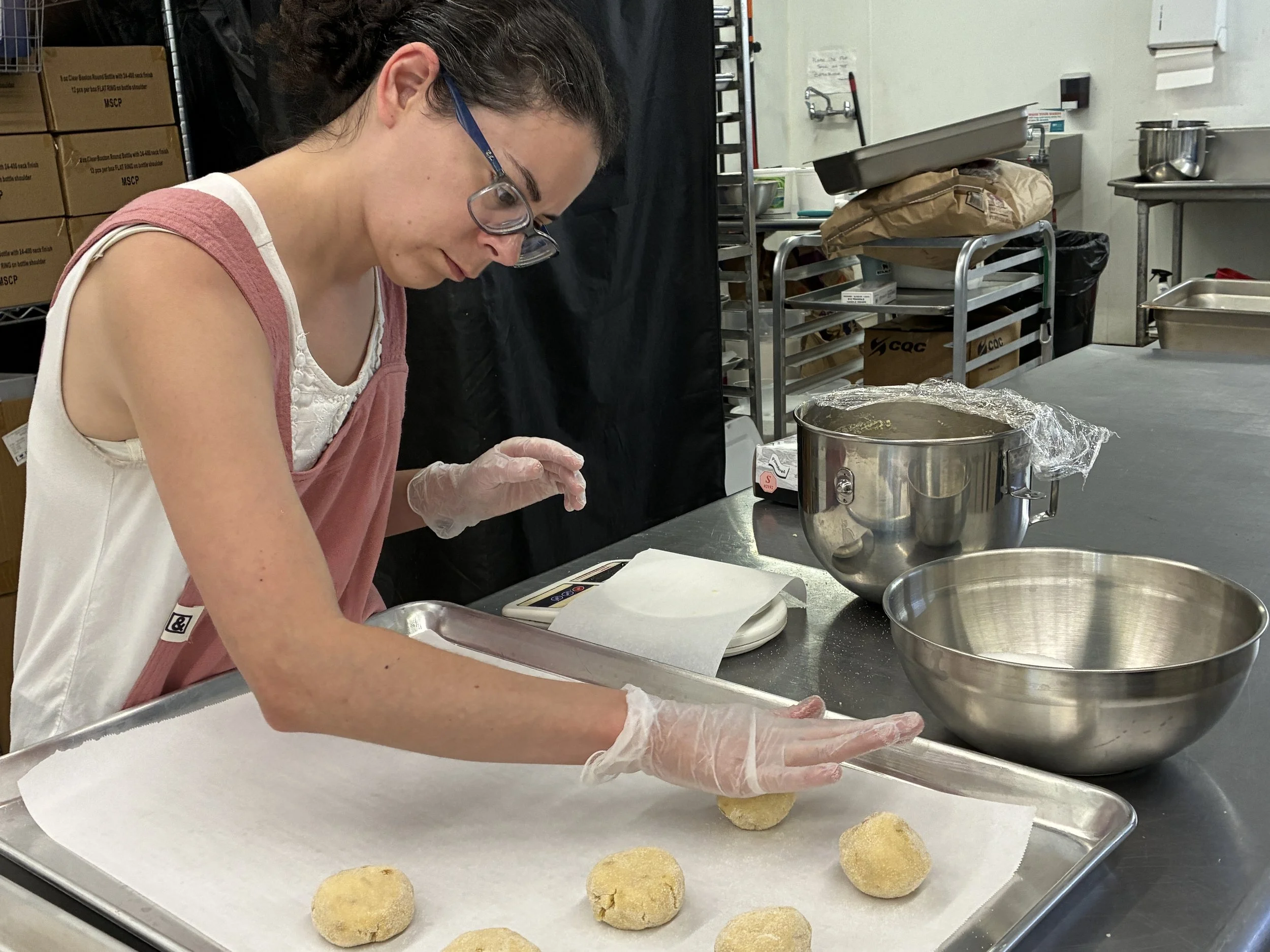 Rachael shaping cookie dough by hand on a baking sheet.