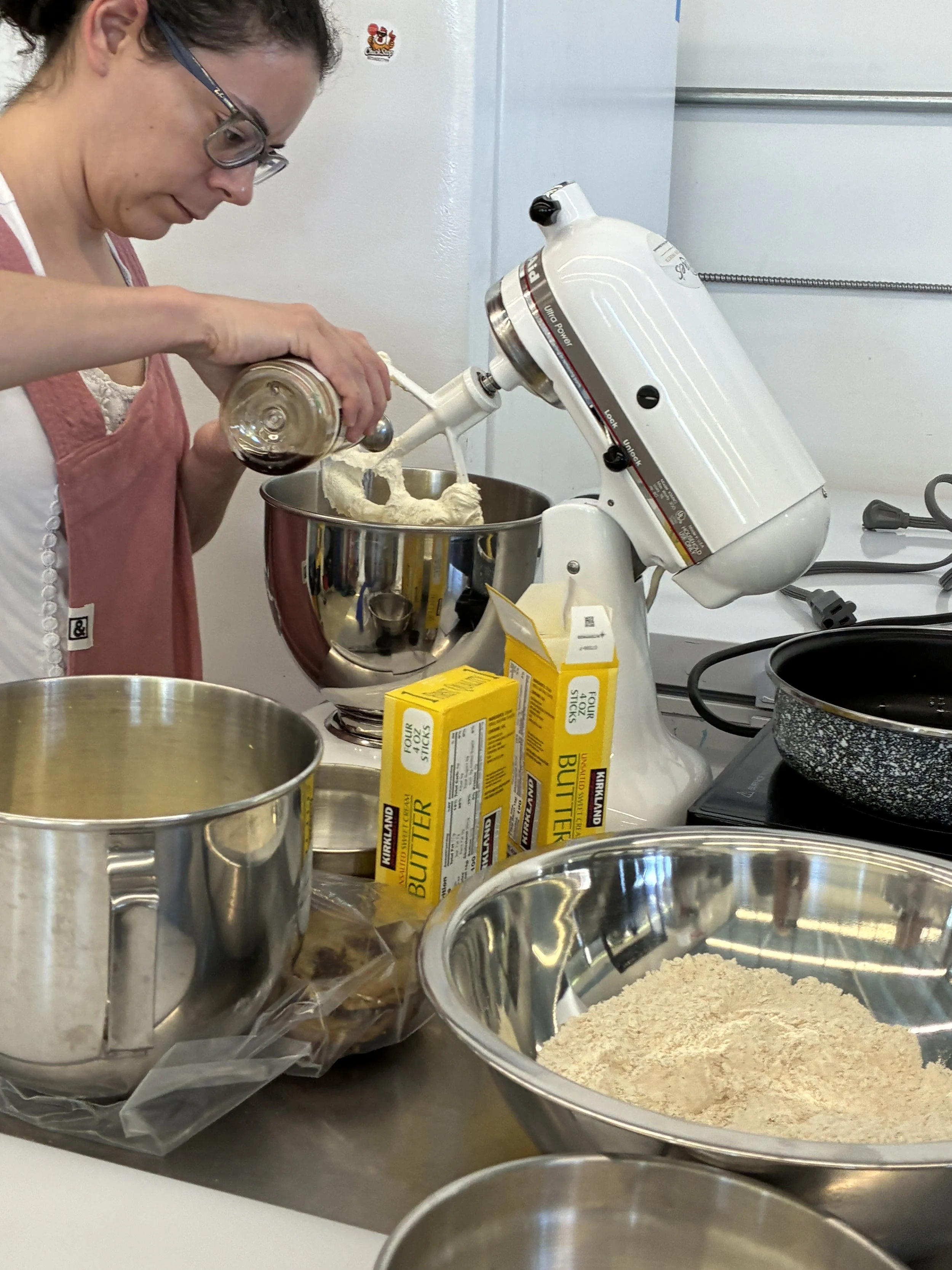 Adding ingredients to the mixer while preparing cookie dough.