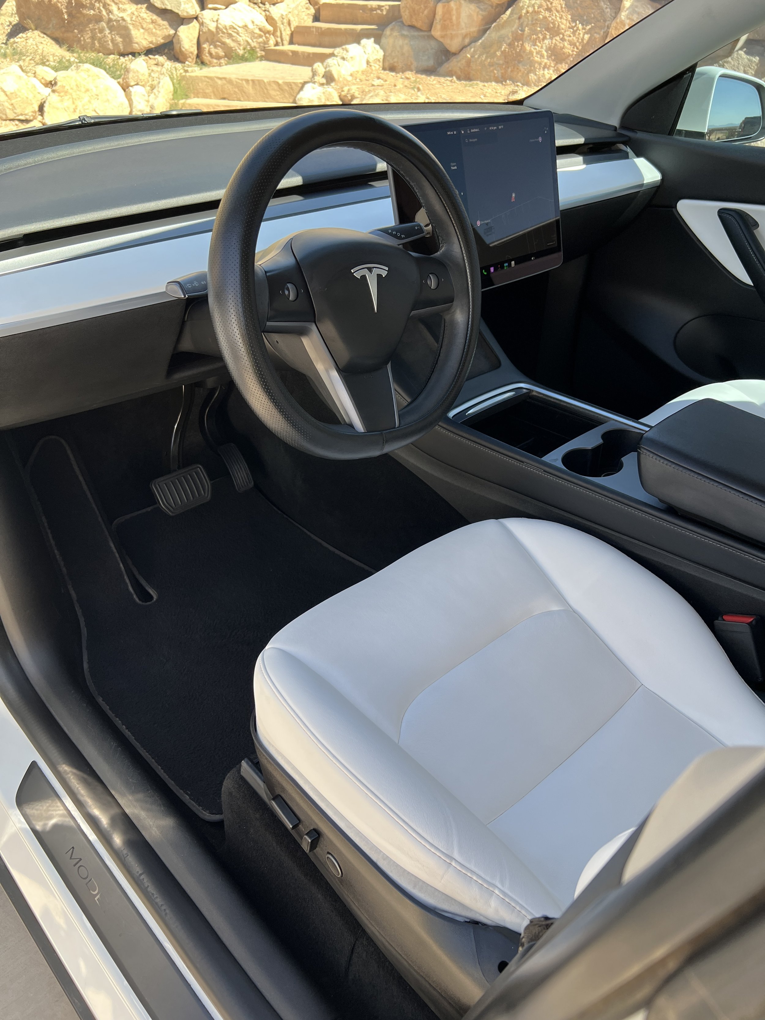 Driver's seat of a Tesla Model Y, showing a basic interior cleaning