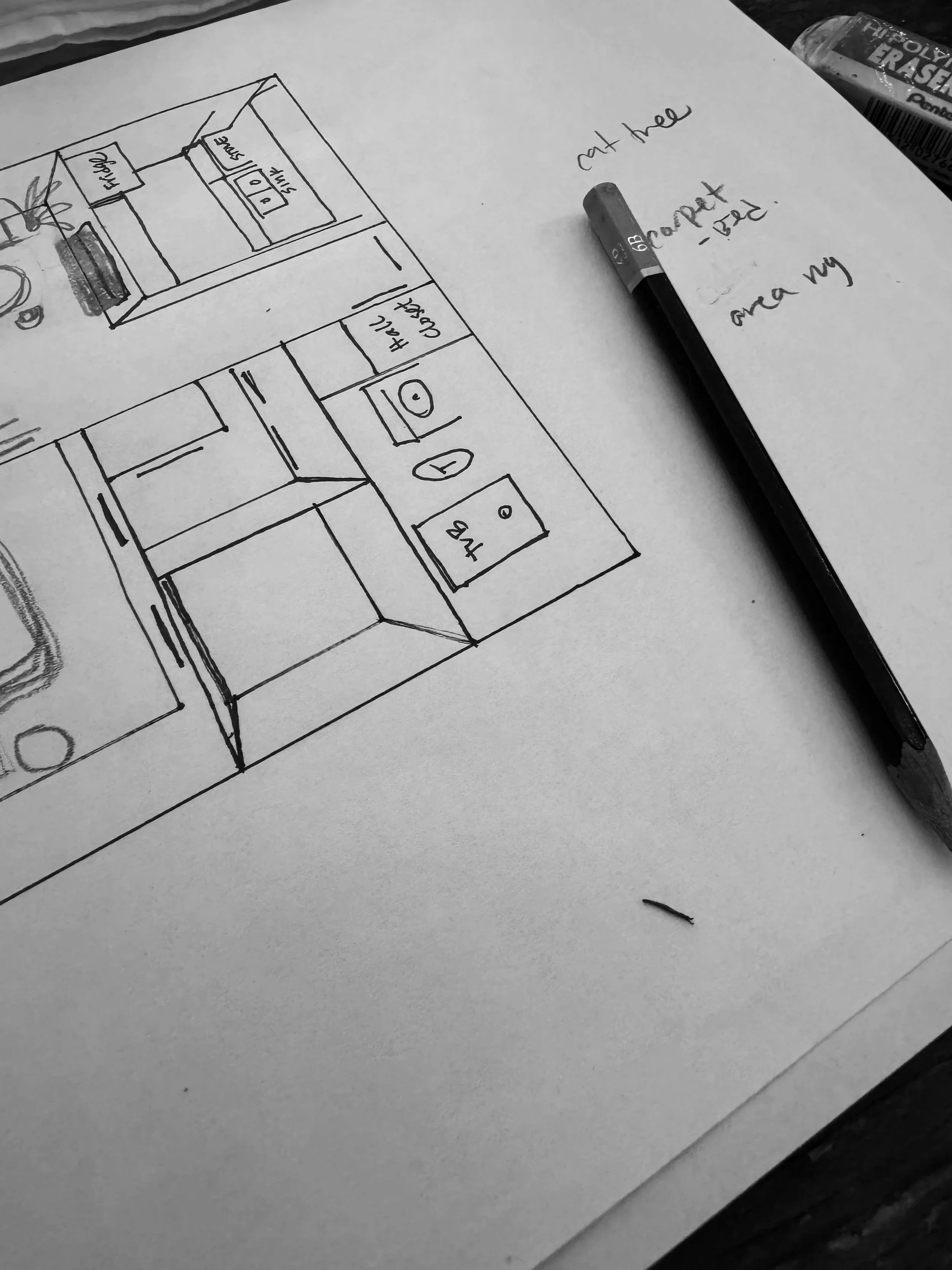 Sketch of an interior room layout with labels, a pen, and a marker on paper.