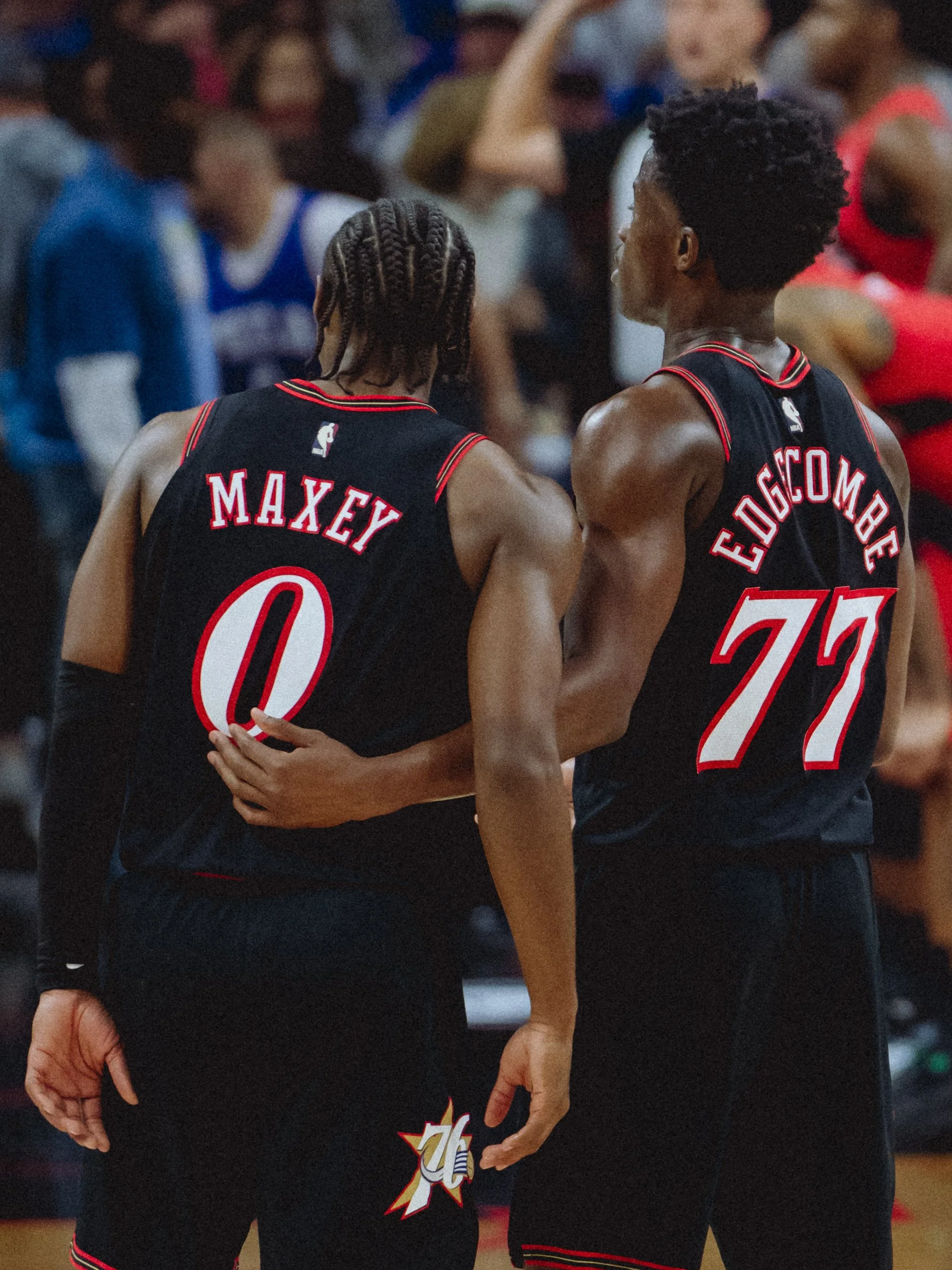 Two basketball players from the Miami Heat team, one with the name Maxey on the back wearing jersey number 0 and the other with the name Cogdice on the back wearing jersey number 22, standing close to each other during a game.