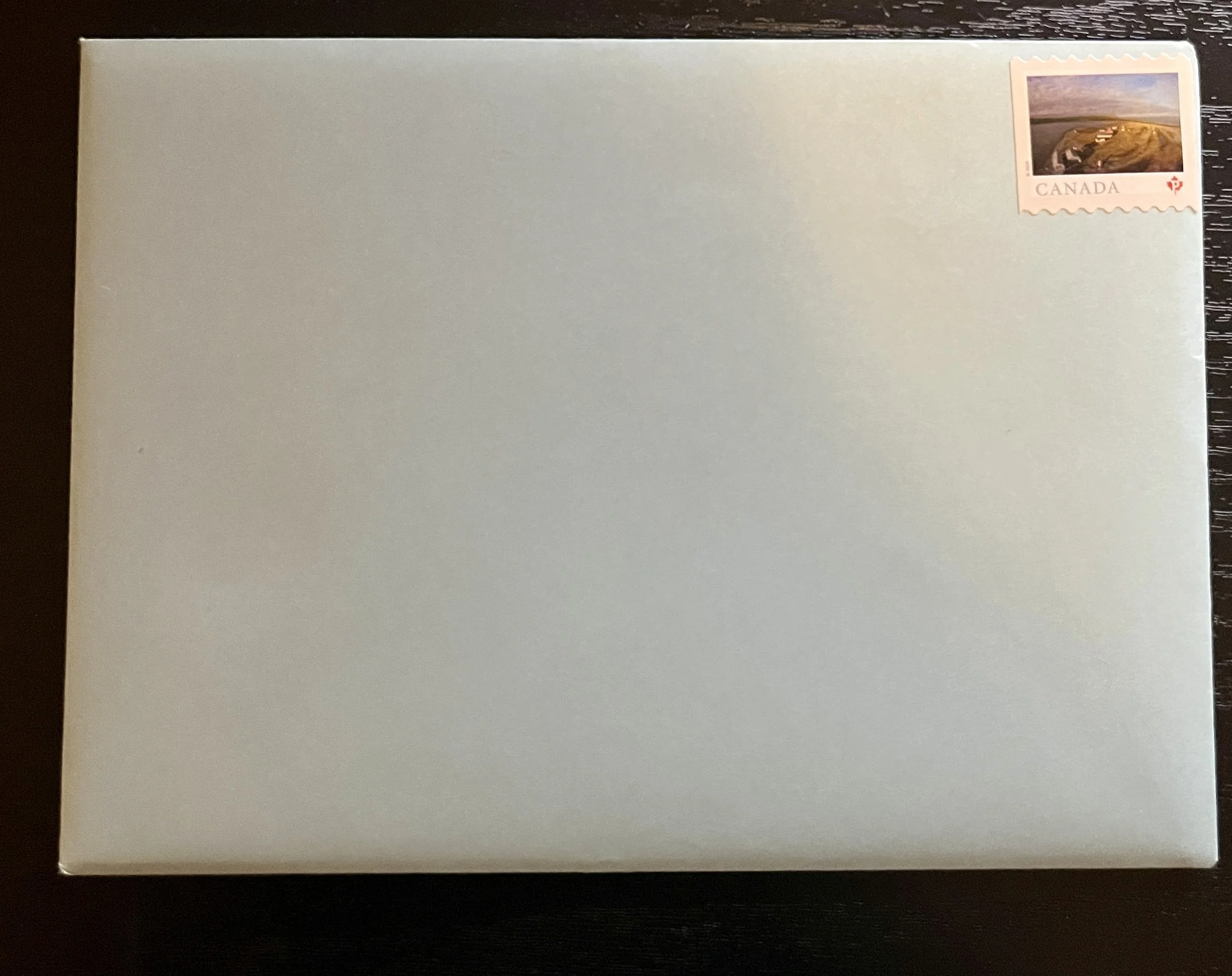 A blank envelope with a Canadian postage stamp in the top right corner.