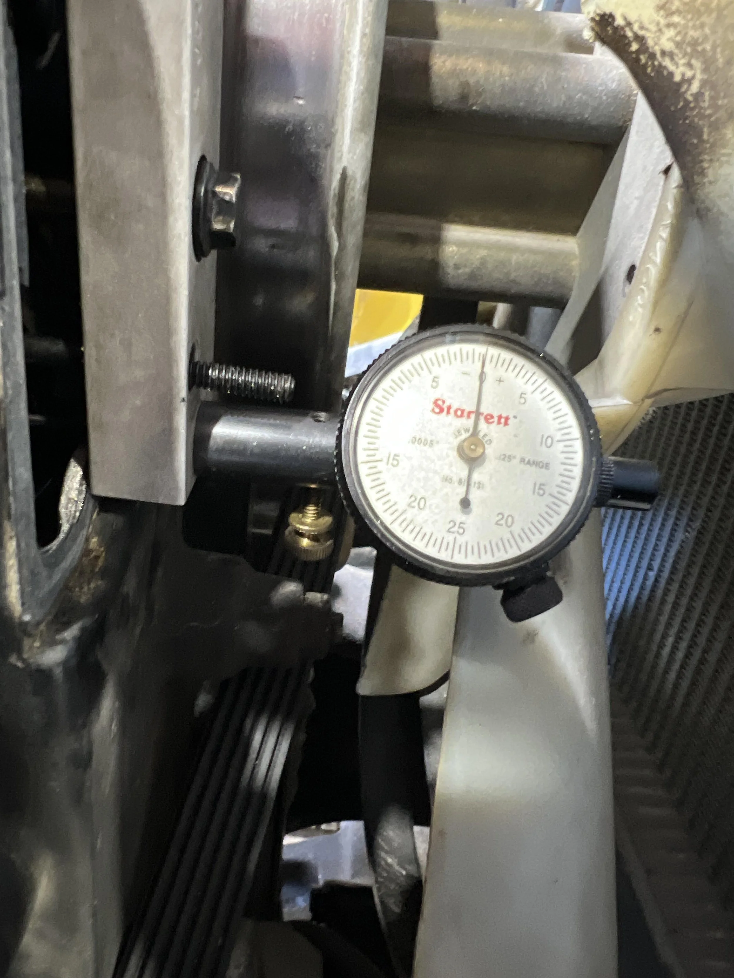 Close-up of mechanical parts including a gauge indicating temperature or pressure, with black cables, and metallic components.