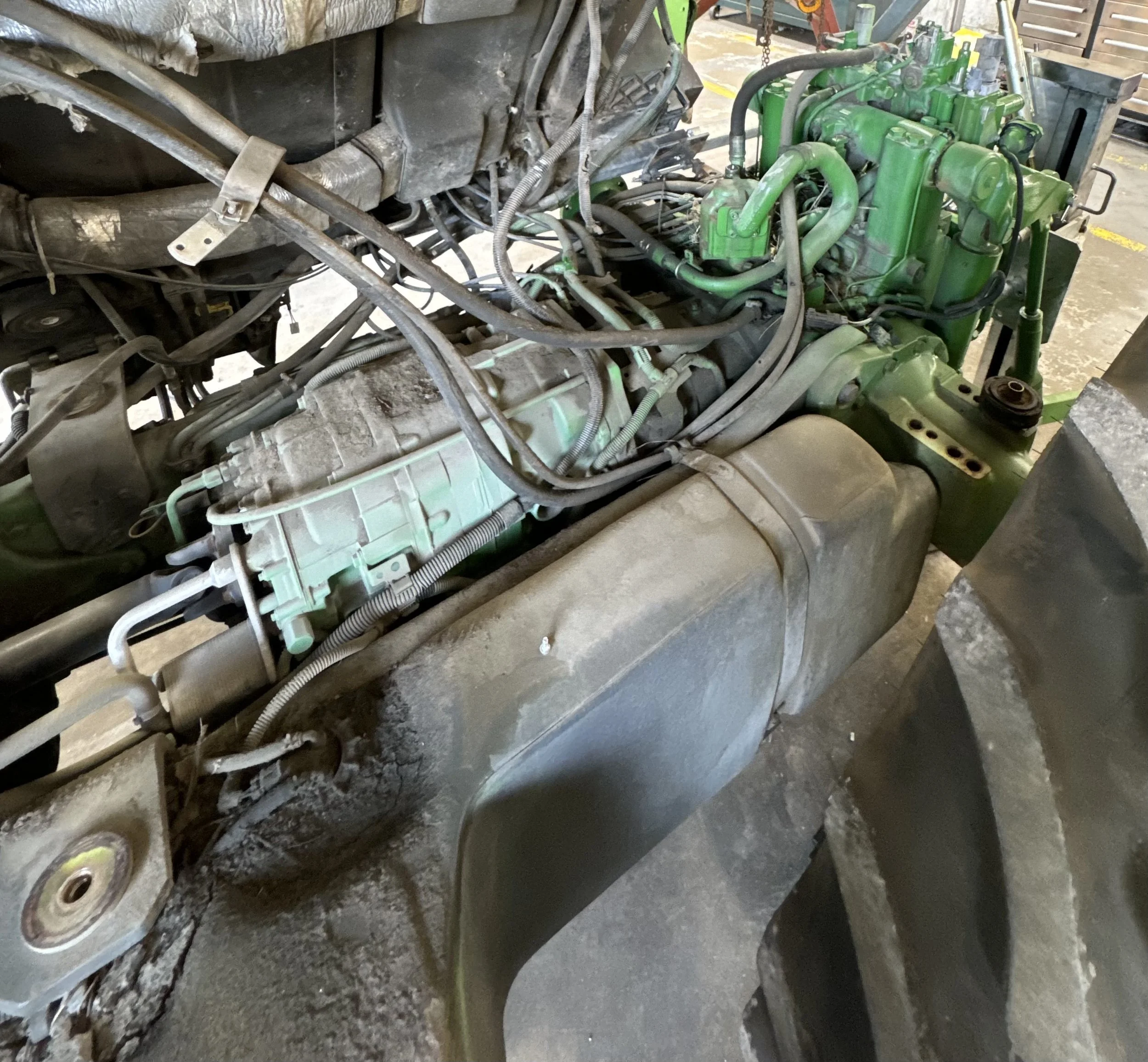 Close-up of a green engine installed in a vehicle frame, with visible wiring, hoses, and components around it.