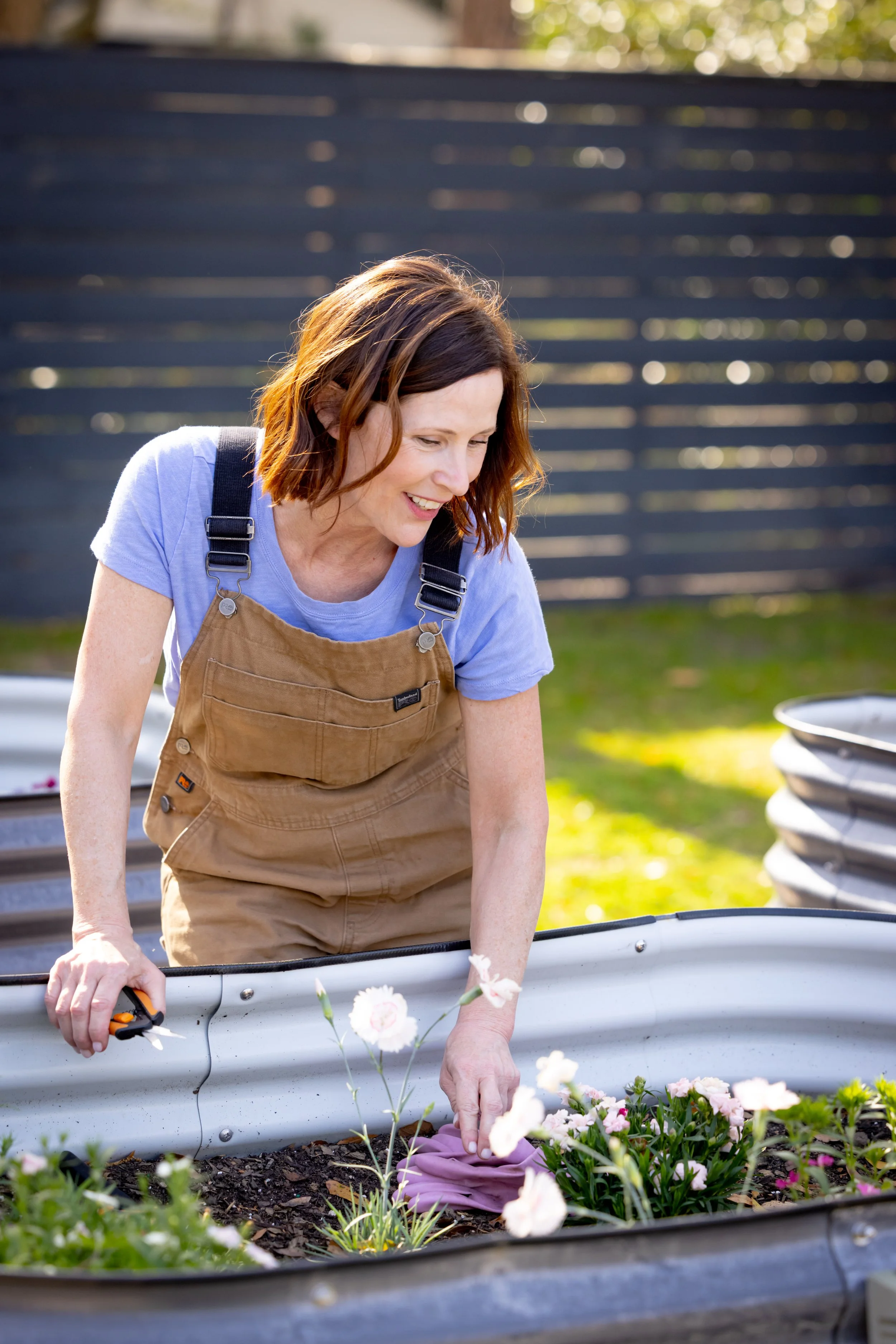 Ann Zalla, owner and artisan pastry chef, tending to edible flower and herb garden at Charleston pastry studio