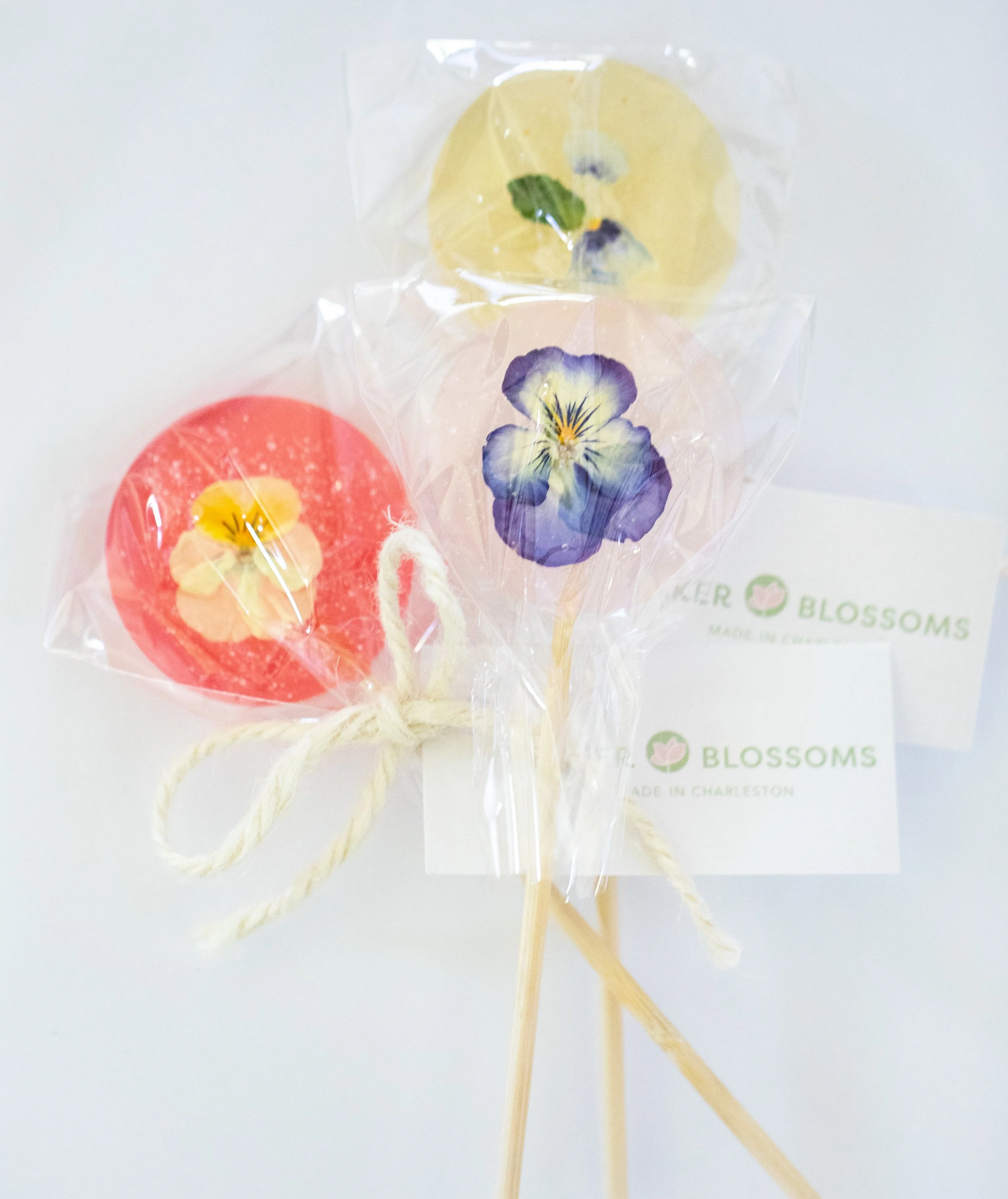Clear bouquet lollipops with pressed edible flowers from Charleston pastry studio—artisanal confections for weddings, private events, and local gifting