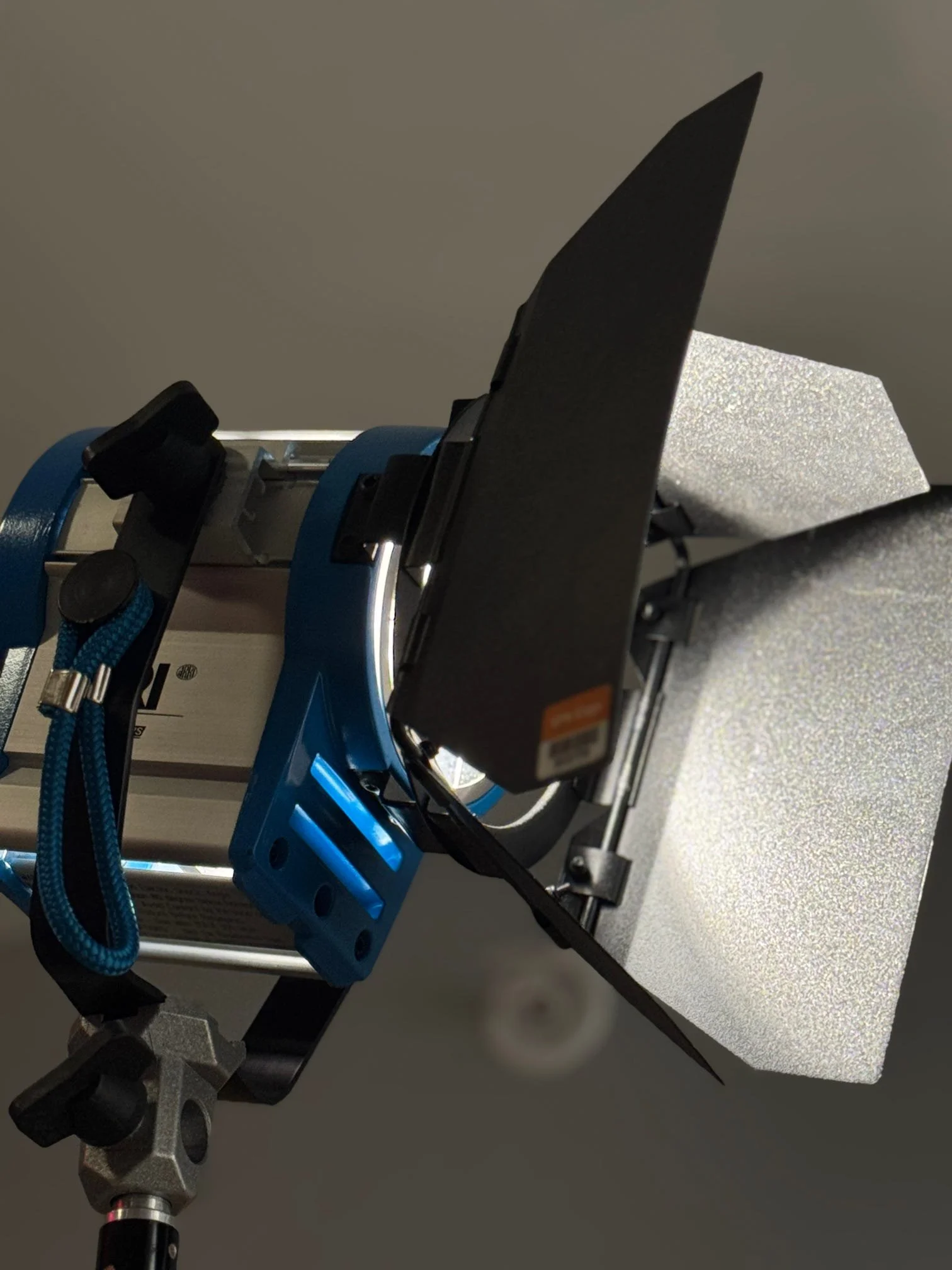Close-up of scientific equipment including a black filter holder with a filter, a blue device, and various metal parts mounted on a laboratory stand.