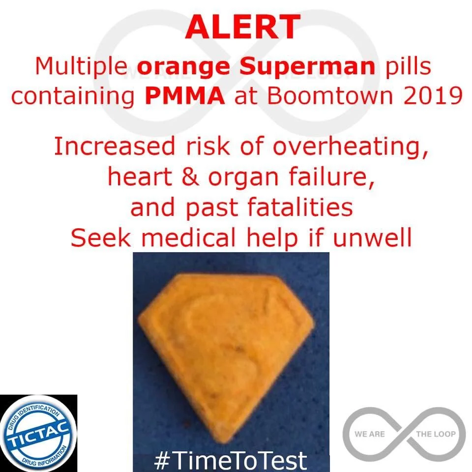 A warning poster about orange Superman pills containing PMA at Boomtown 2019, warning of health risks, with a photo of a pill and drug safety logos.